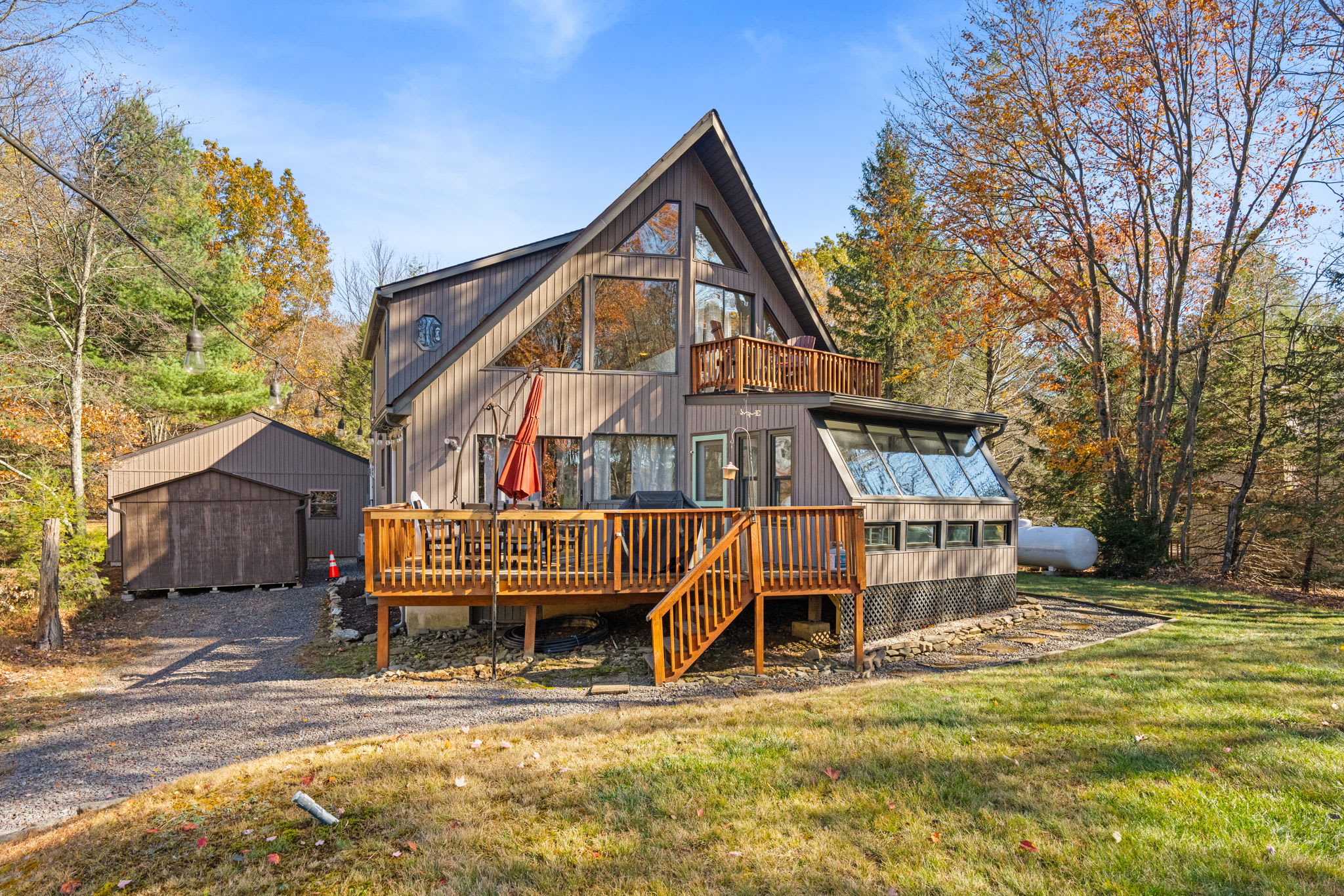 Stunning A-frame architecture with expansive deck overlooking wooded lot - classic mountain cabin design