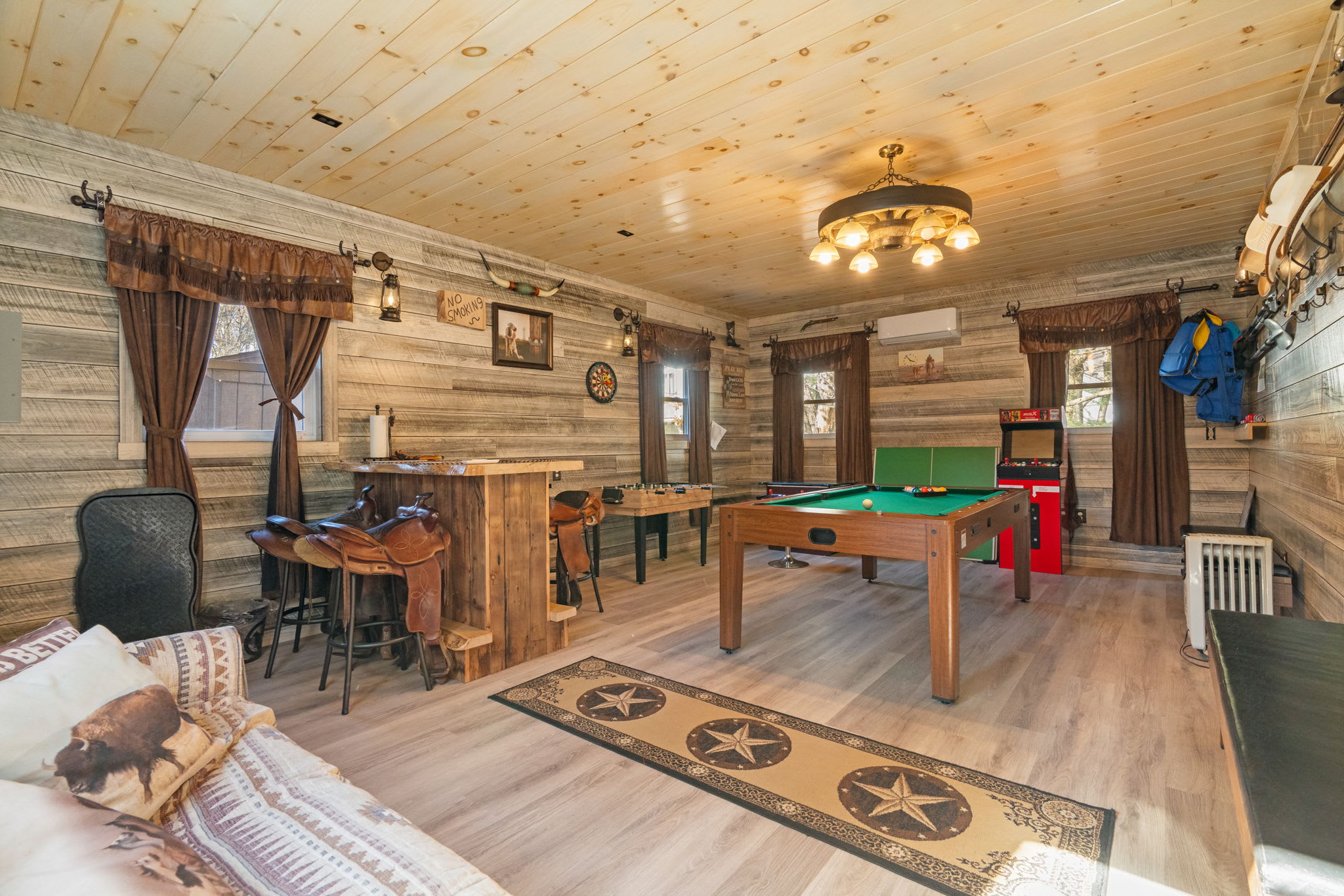 Entertainment game room with pool table, foosball, bar area, and lounge seating - endless fun for all ages