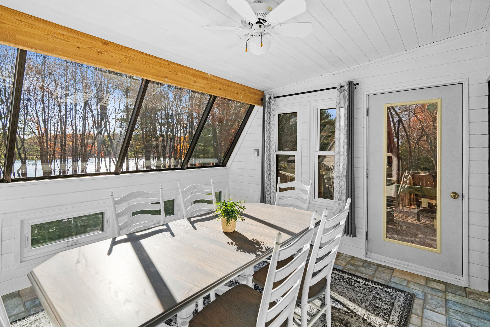 Sunroom seating with white railings and natural light - additional living space with skylight views