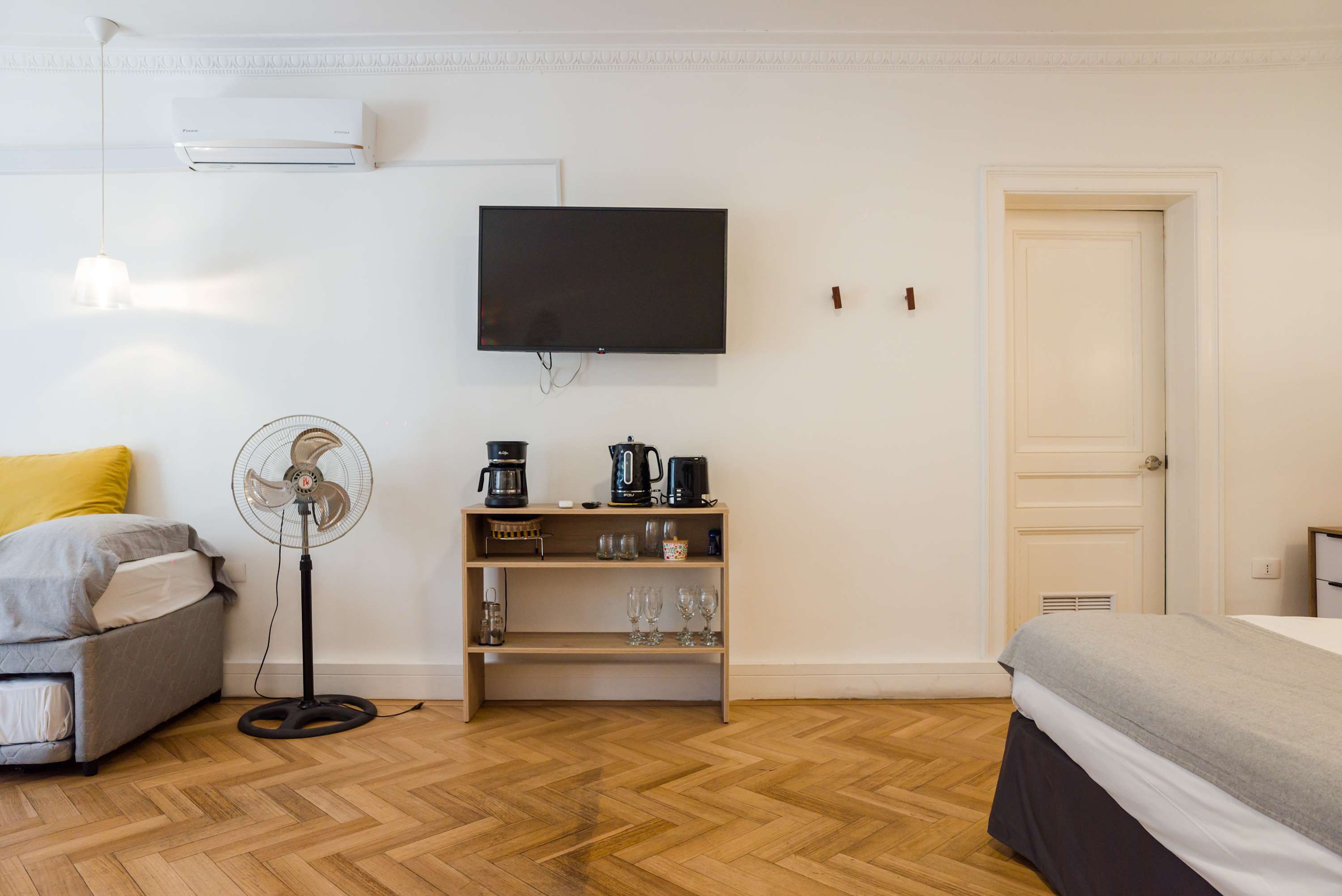 Cozy studio with modern amenities, including a wall-mounted TV and coffee station, perfect for a relaxing stay.