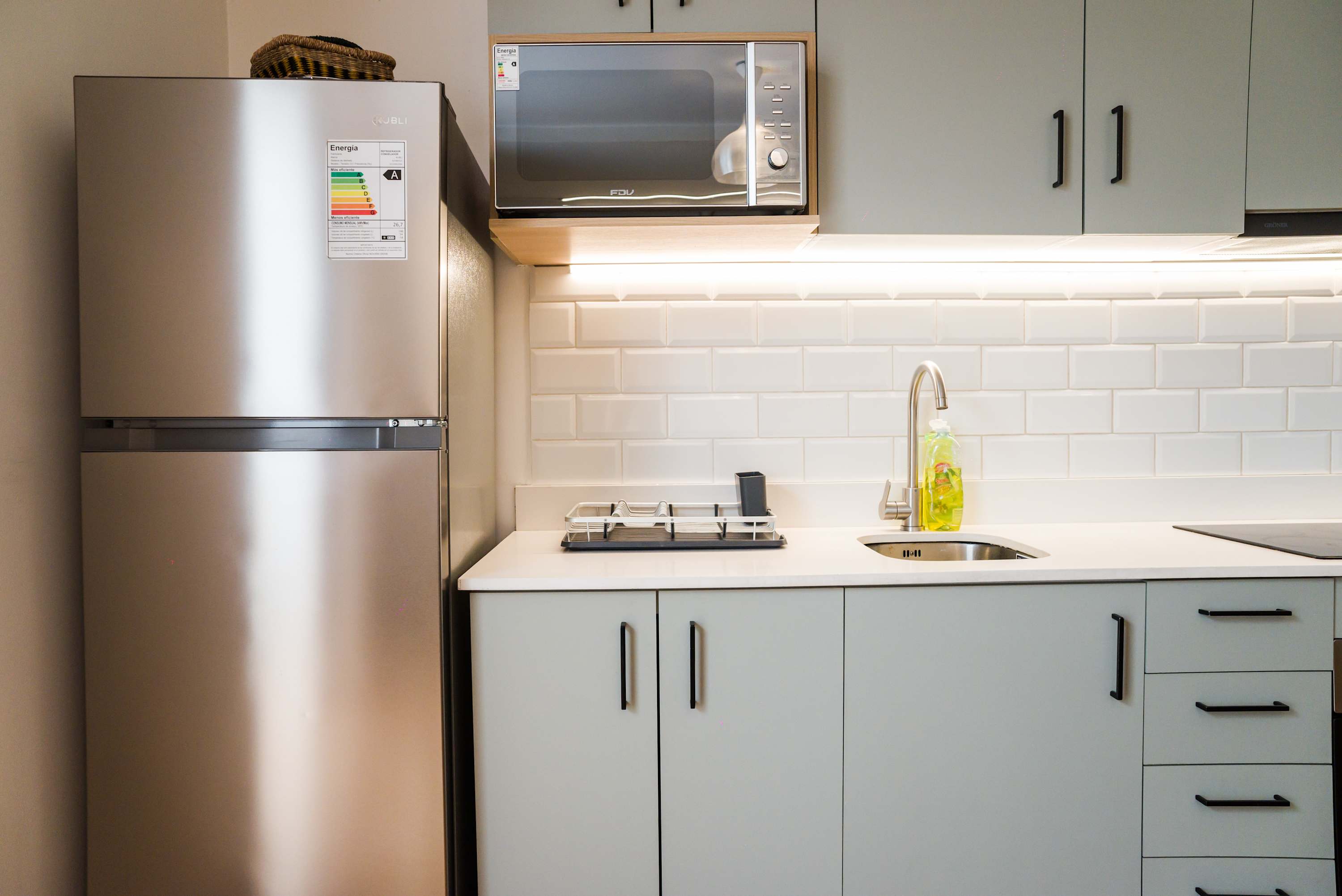 Modern kitchen with sleek appliances and stylish backsplash, perfect for cooking at home.