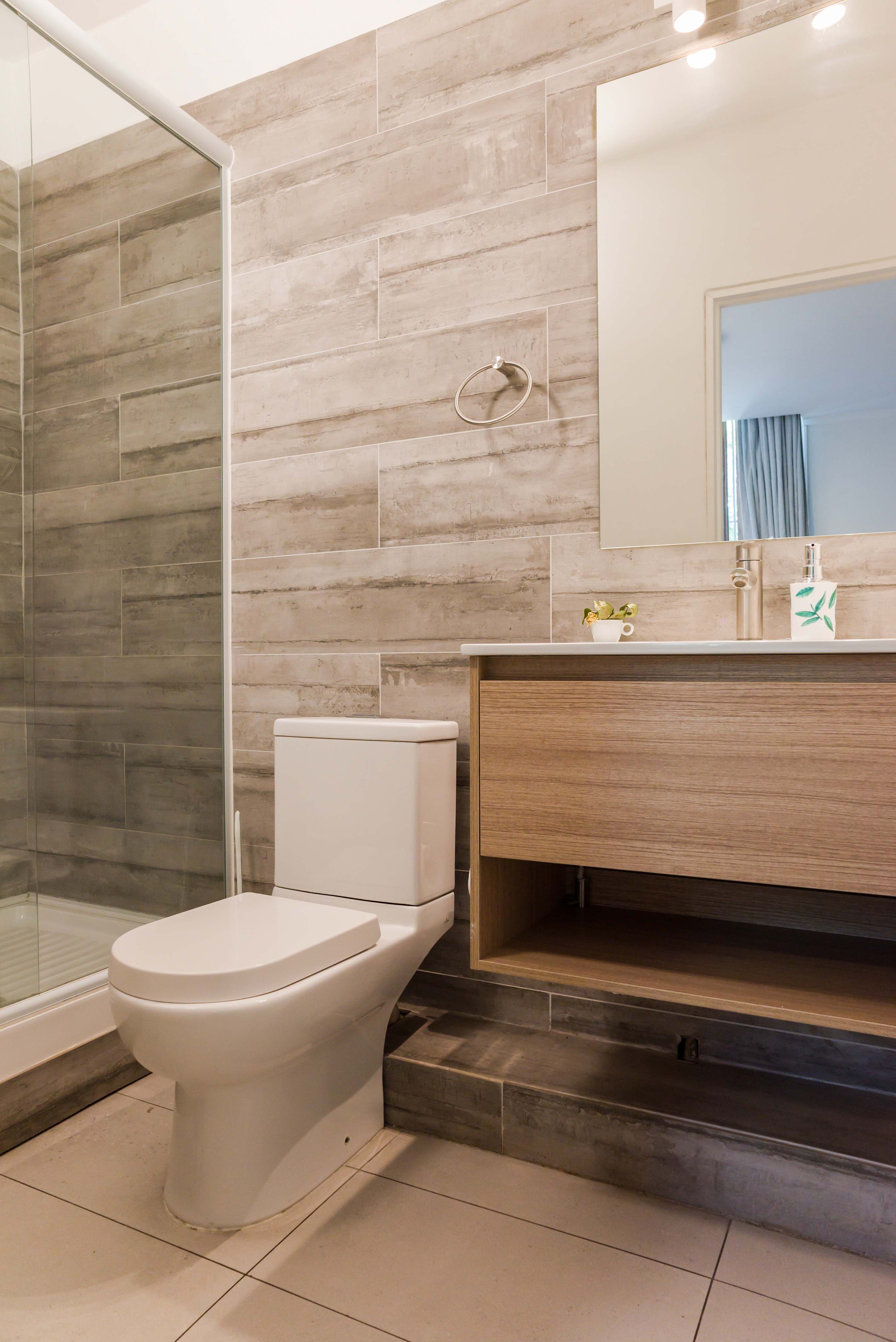Modern bathroom with sleek fixtures and a spacious shower, perfect for a relaxing start or end to your day.