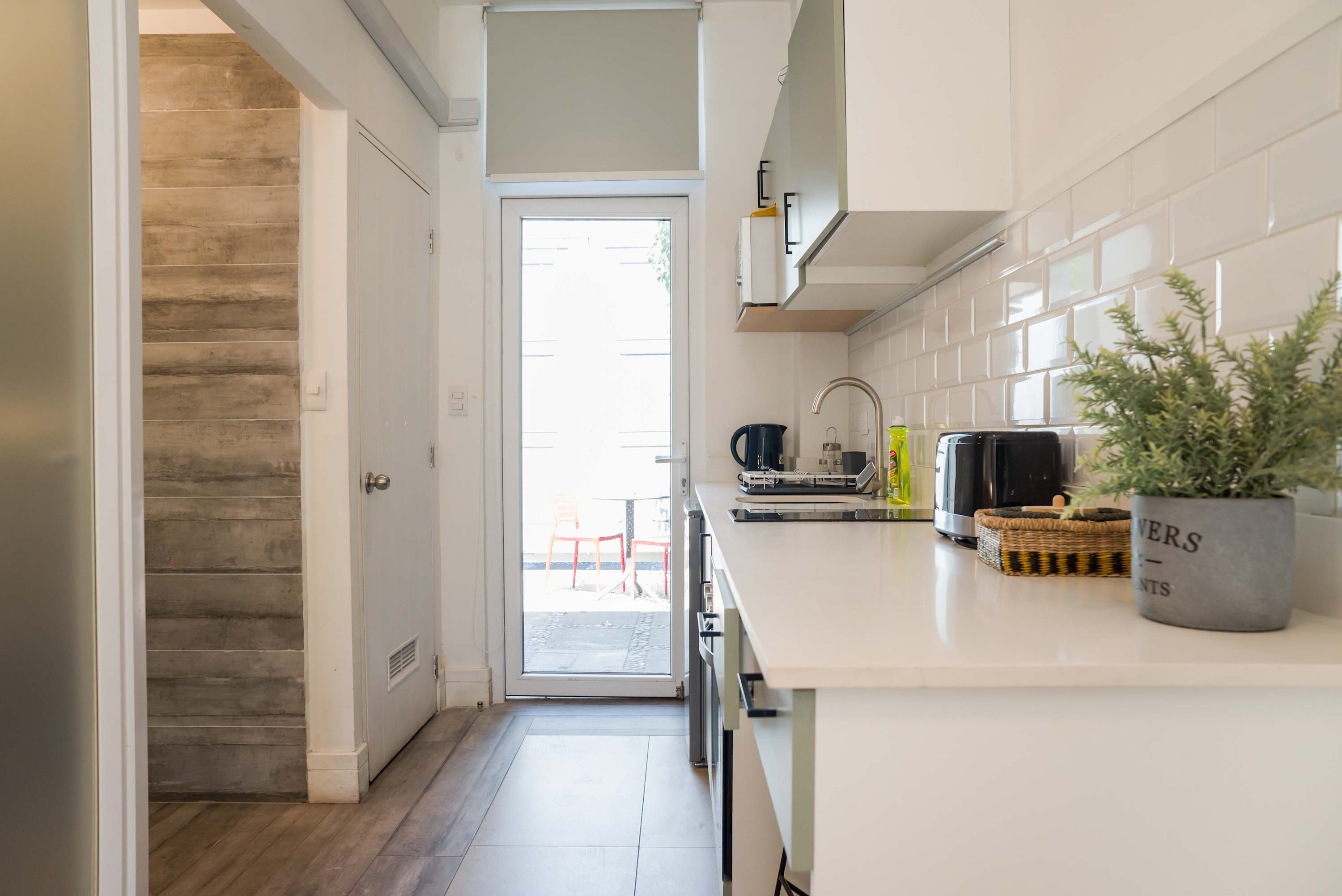 Modern kitchen with sleek appliances and access to a cozy outdoor space, perfect for morning coffee.
