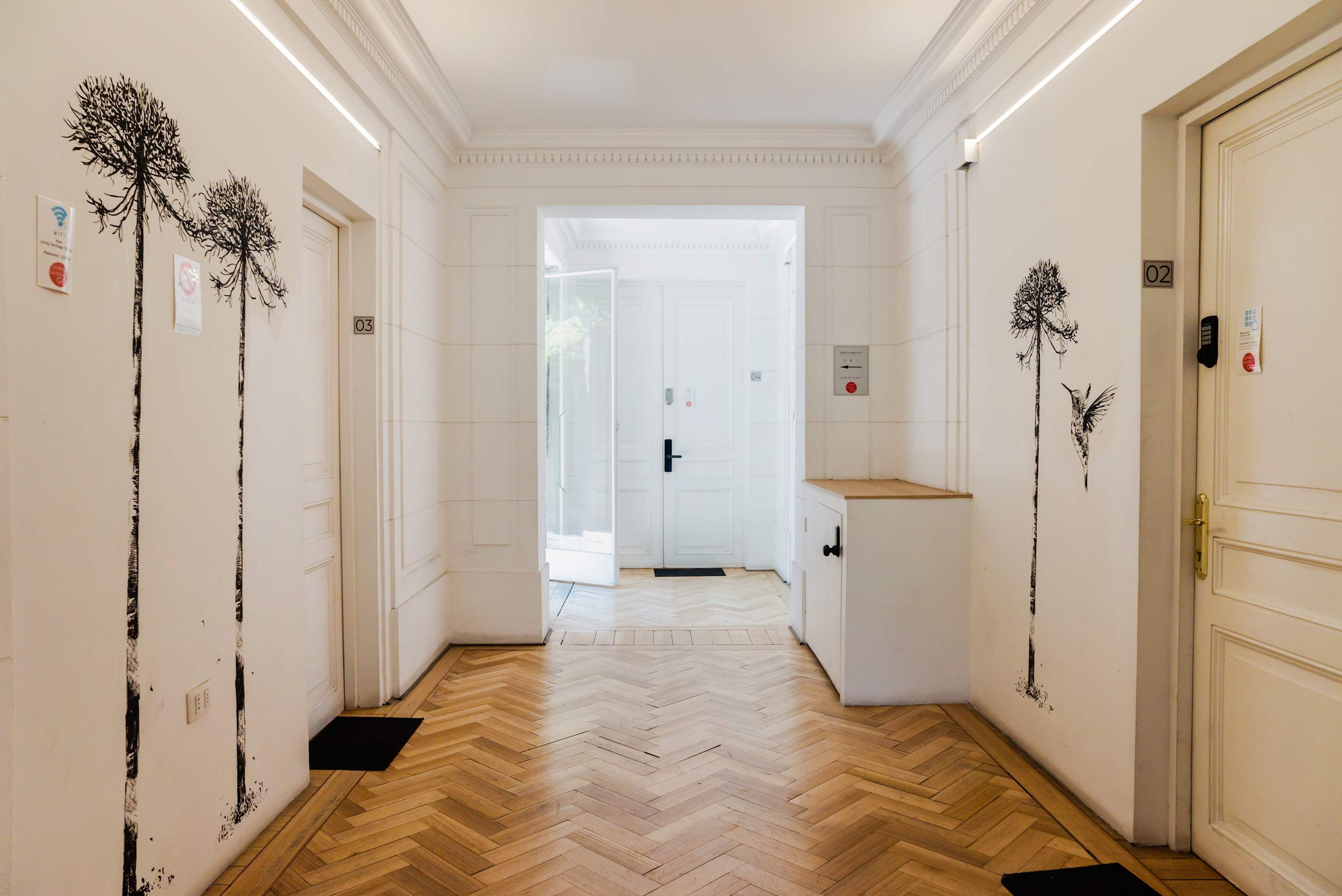 Bright and welcoming hallway with artistic wall decor and elegant flooring.