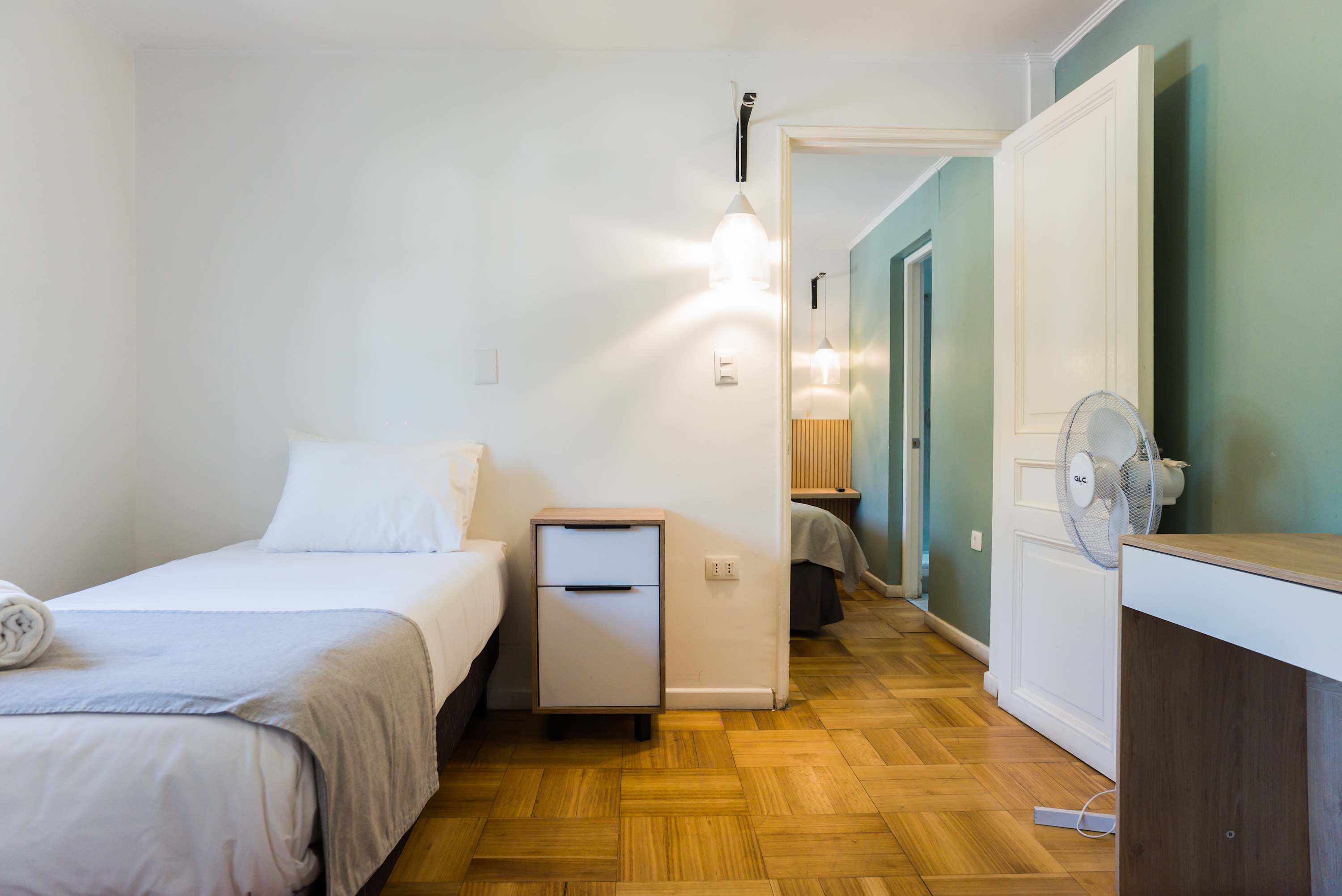 Relax in a cozy bedroom with a comfortable single bed and modern decor, perfect for a restful stay.