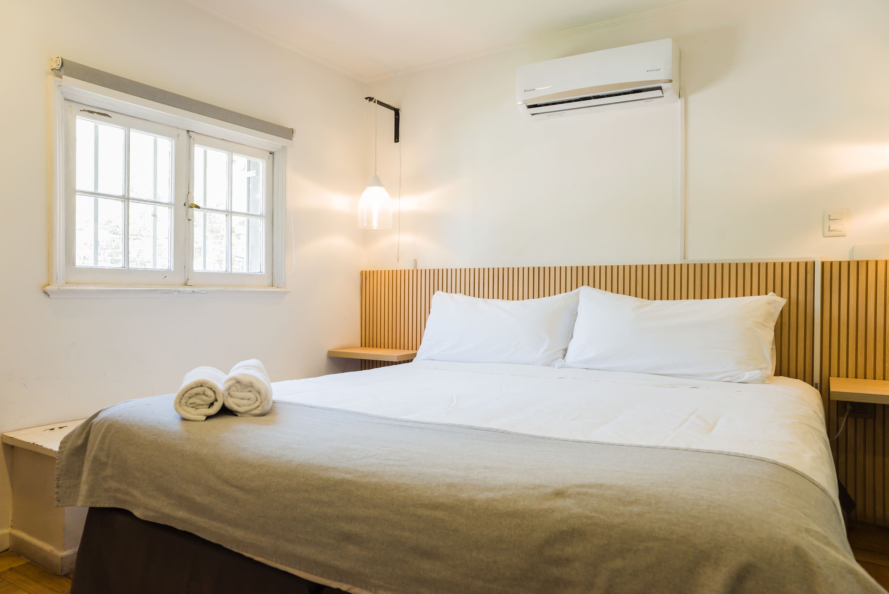 Relax in this cozy bedroom with natural light and modern amenities, perfect for a restful stay.