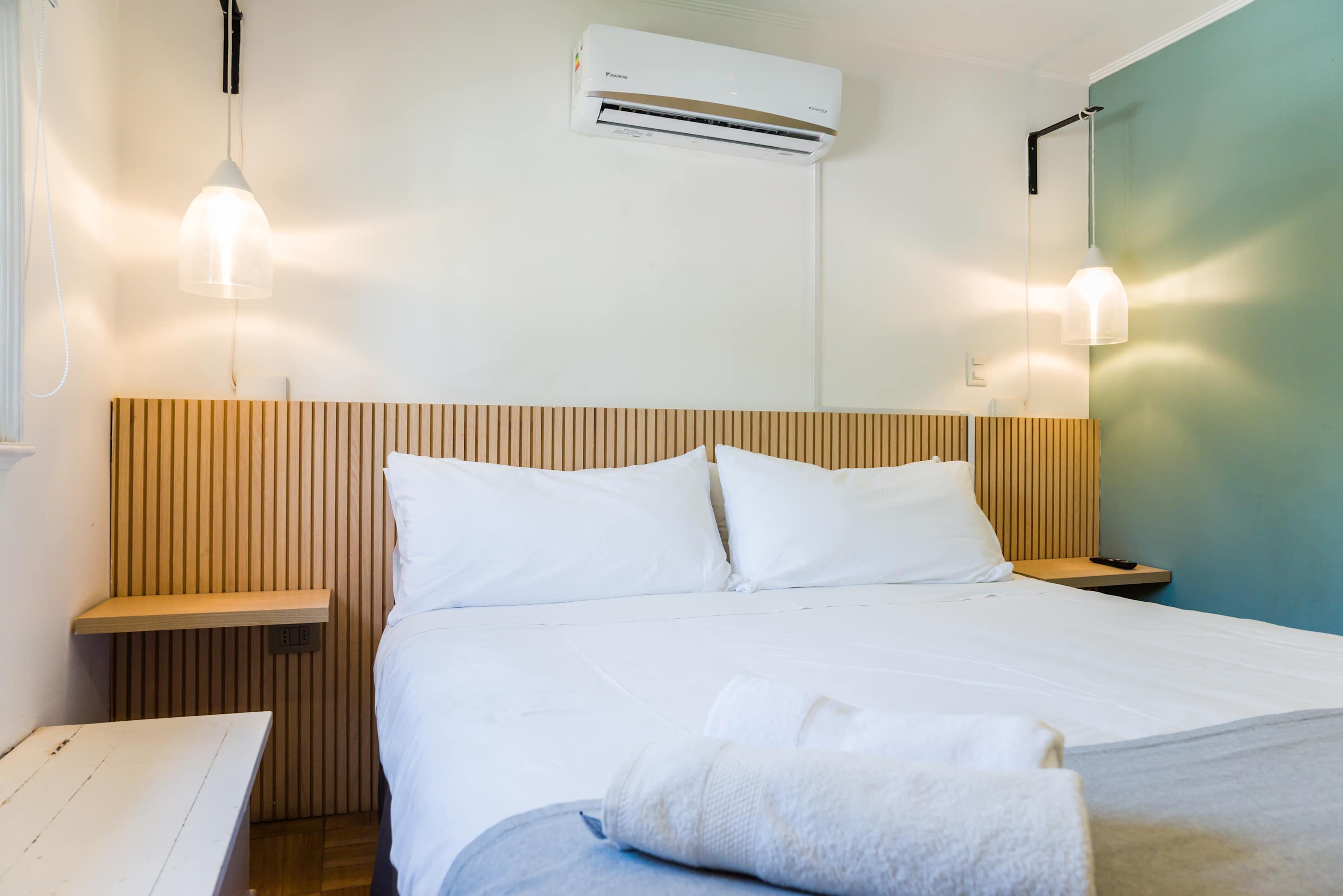 Unwind in this stylish bedroom with cozy bedding and modern lighting for a perfect night's sleep.