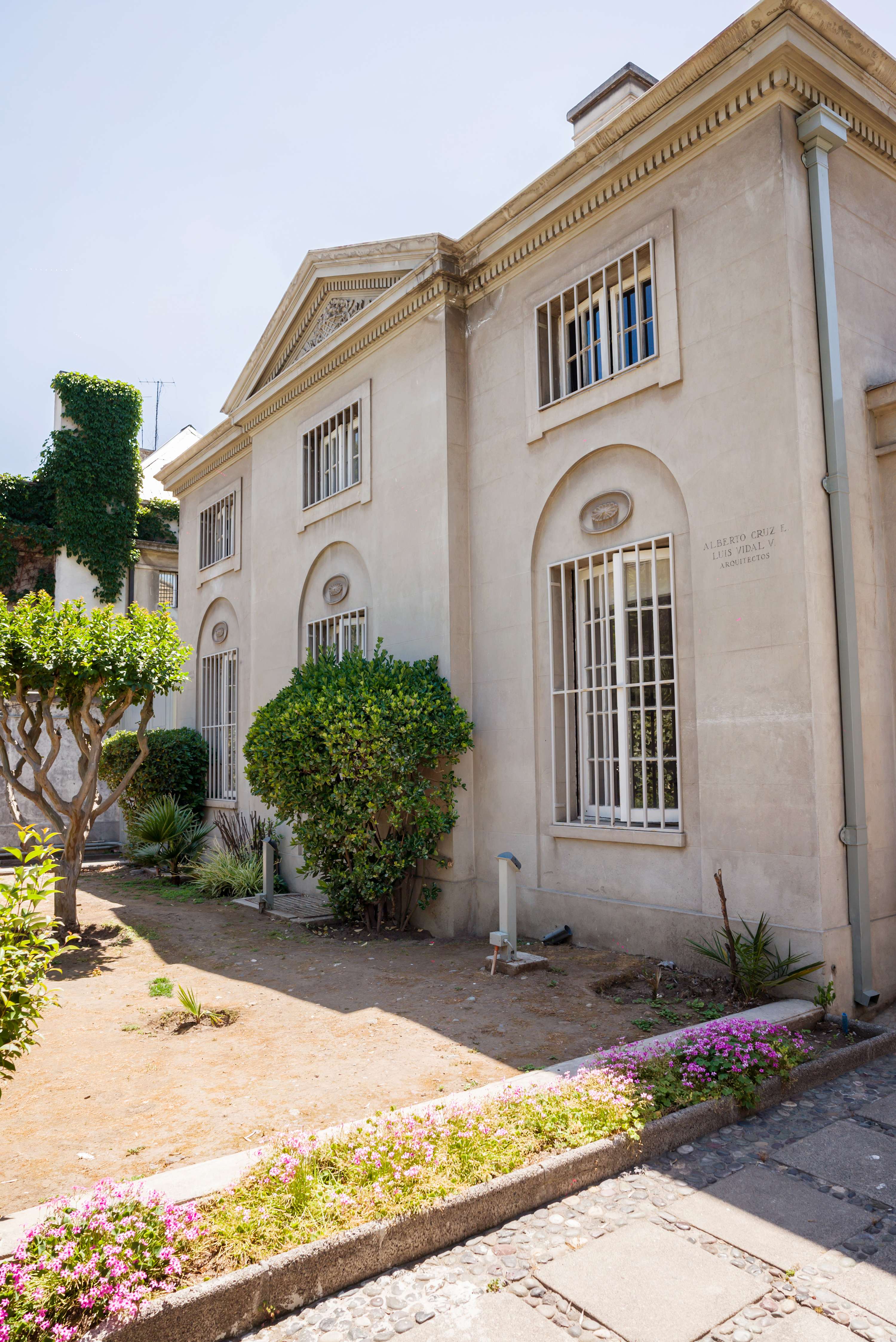 Charming historic facade with lush garden views, perfect for a serene stay in Chile.
