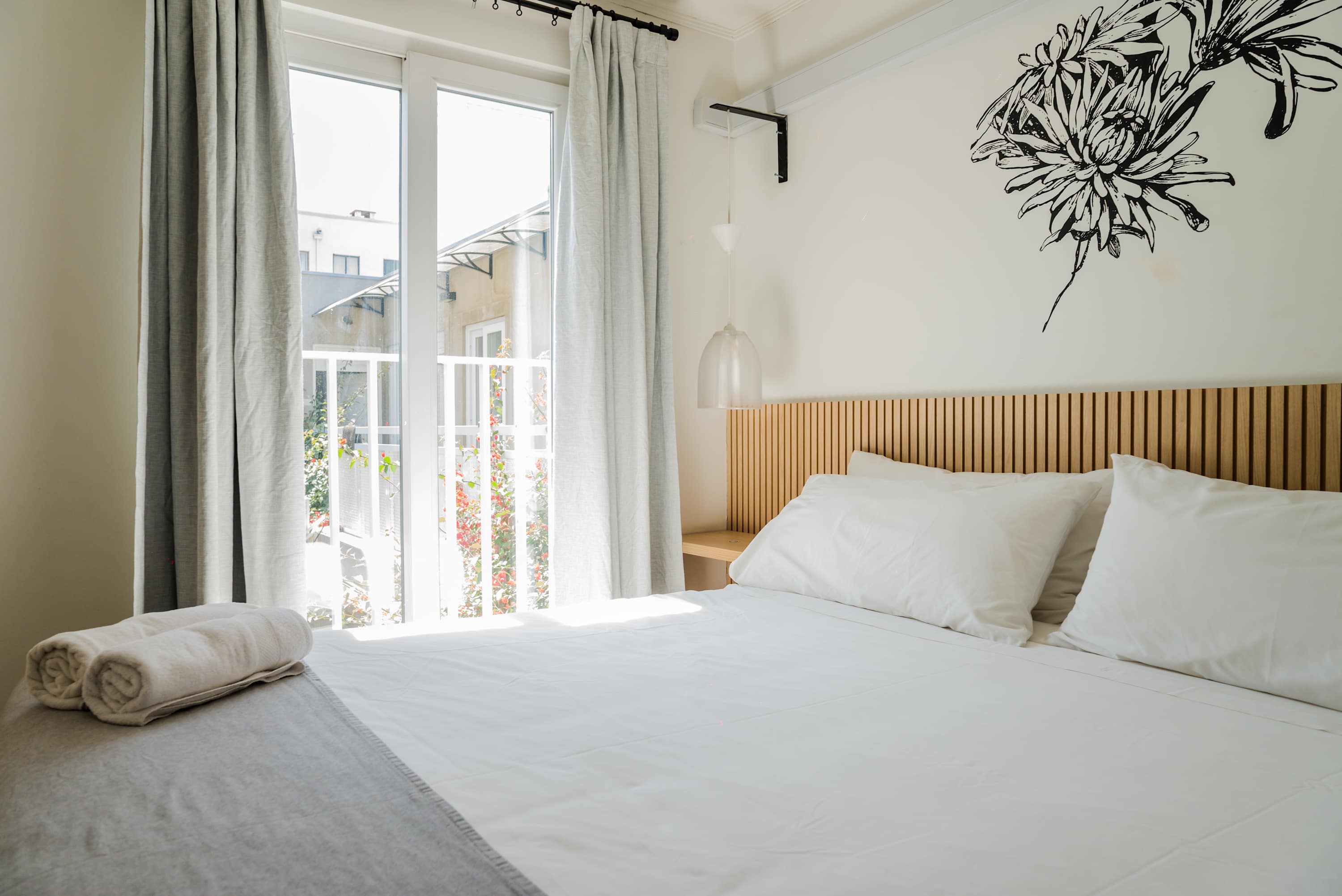 Cozy and bright bedroom with balcony access, perfect for relaxation in the heart of the city.