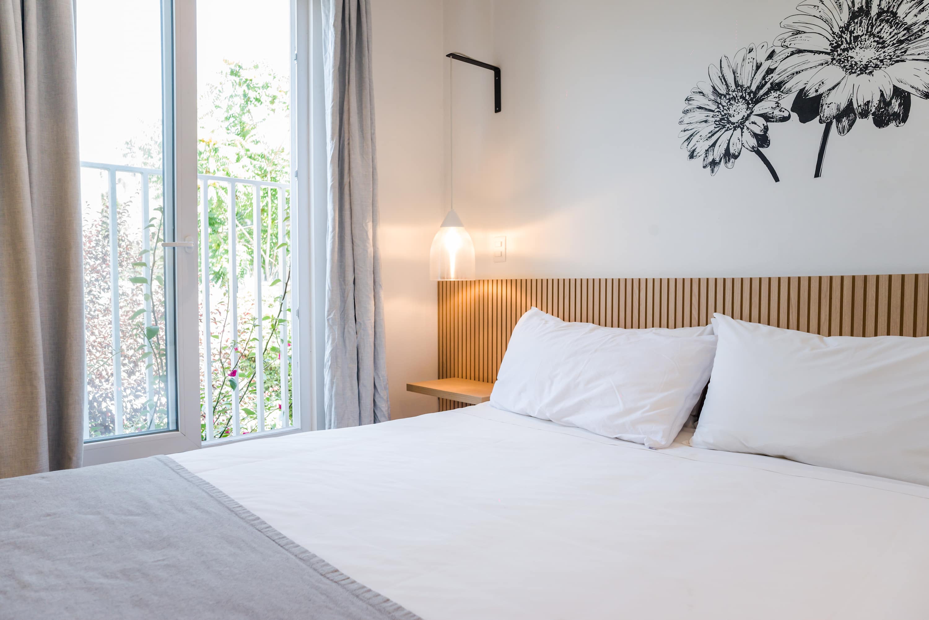 Cozy and bright bedroom with modern decor and natural light, perfect for a relaxing stay.