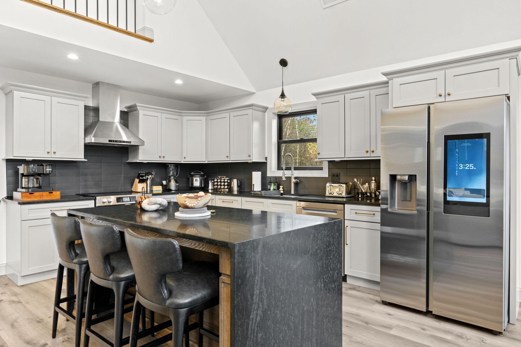 Gourmet kitchen with island bar seating and scenic views through large windows