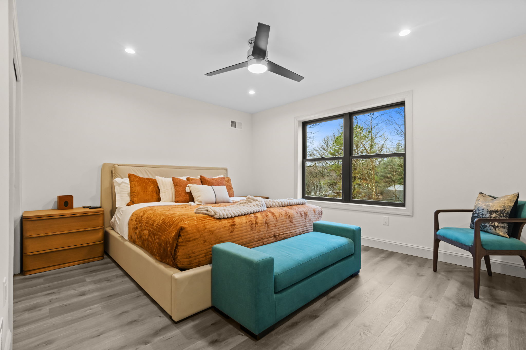 Catch a breeze from the ceiling fan and enjoy the forest views from this vibrant bedroom