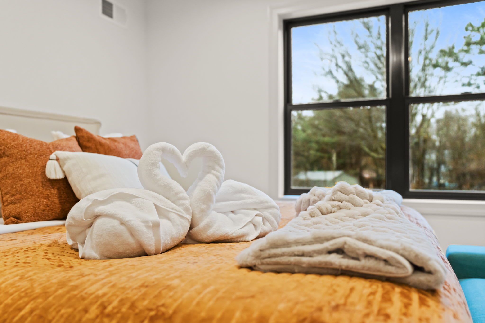 Discover sweet towel art and inviting bedding waiting for you in this cozy room