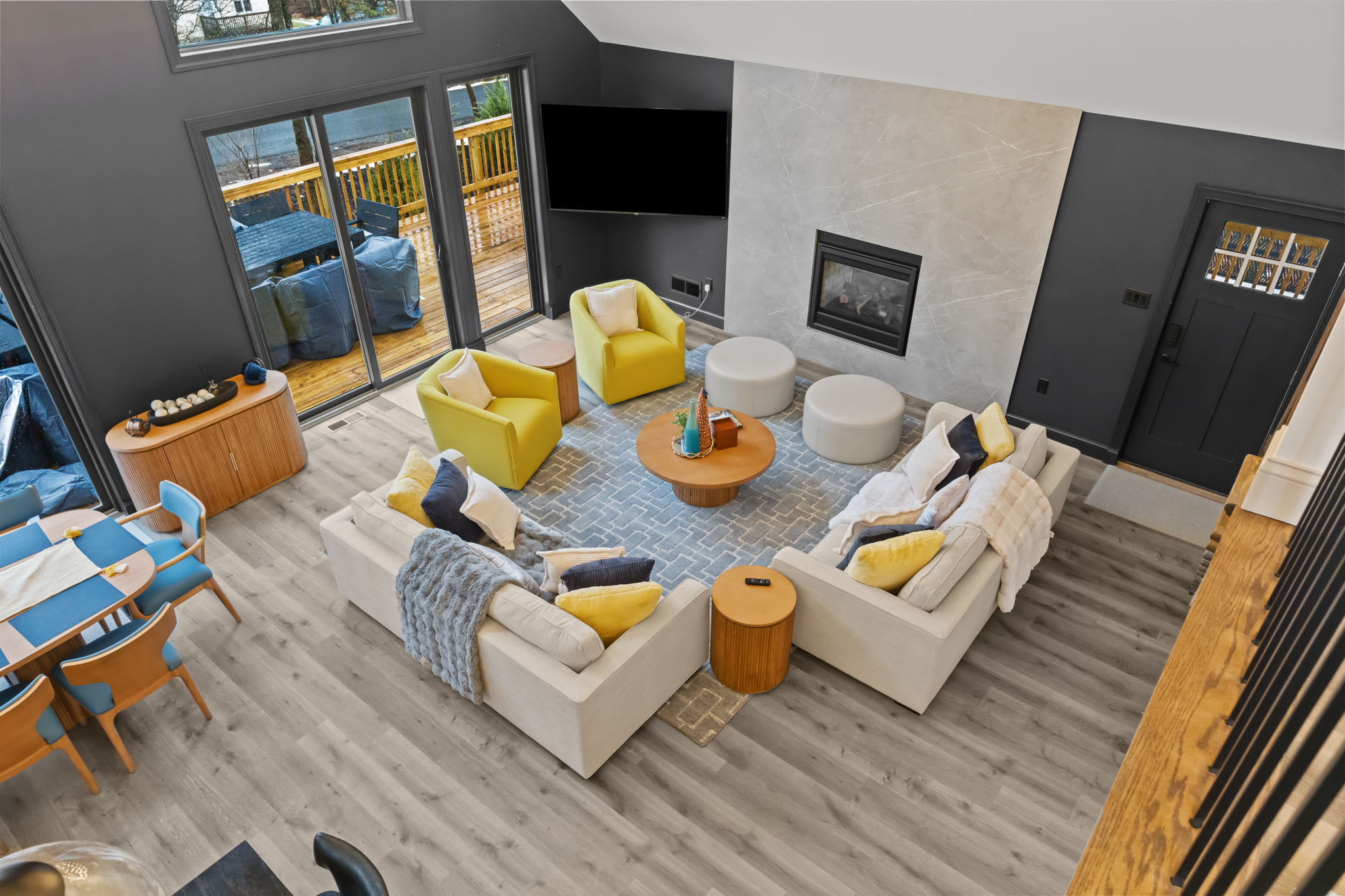 Look down from the loft to the open living room with its cozy seating and elegant chandelier