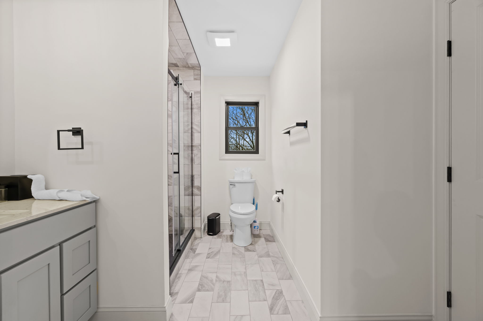 Step into the marble-accented bathroom featuring a walk-in shower
