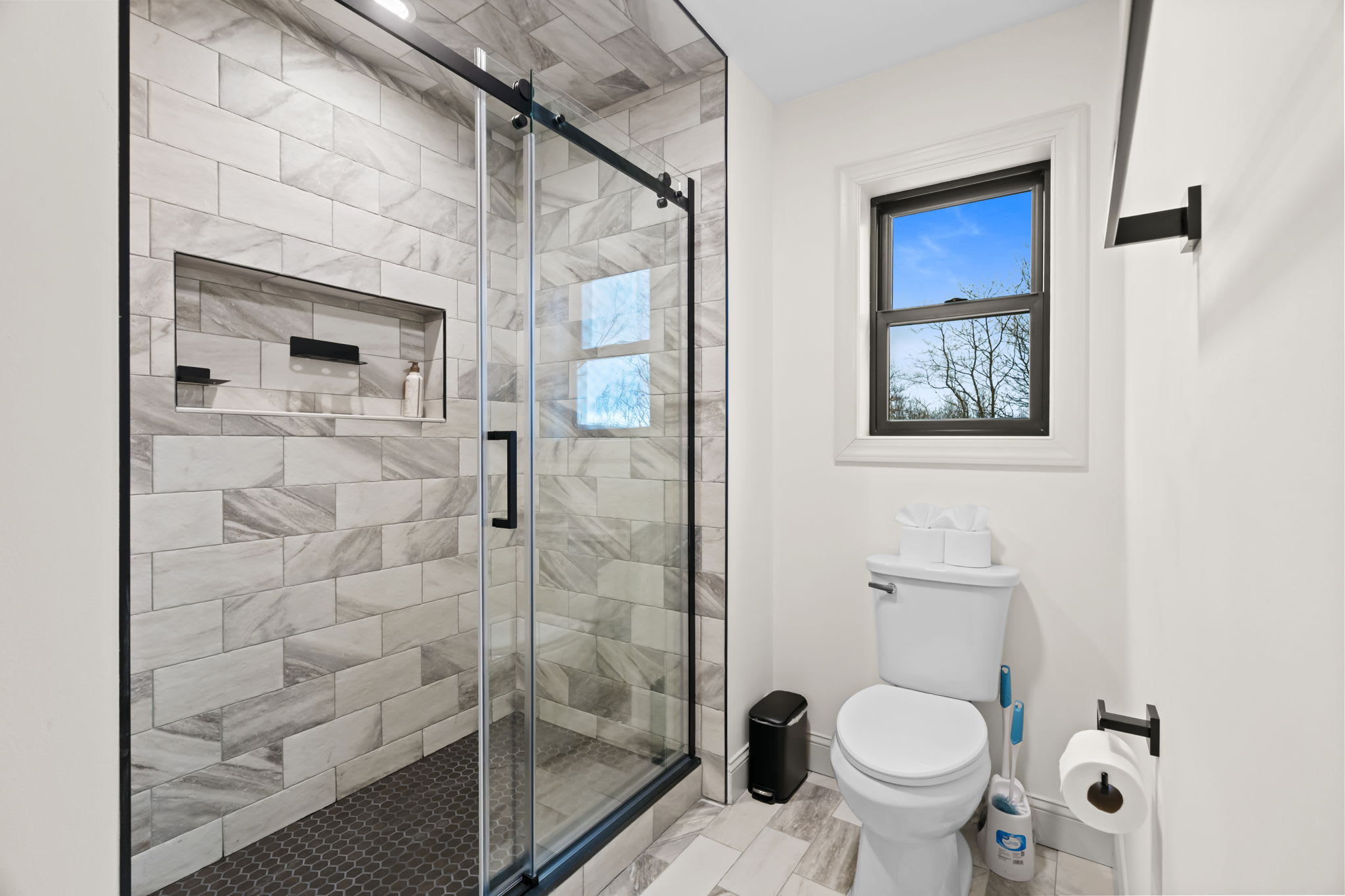 Modern bathroom with gray vanity and spacious glass-enclosed shower