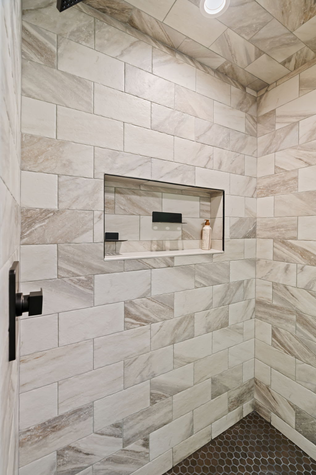 Refresh in the marble-tiled walk-in shower with natural light streaming in