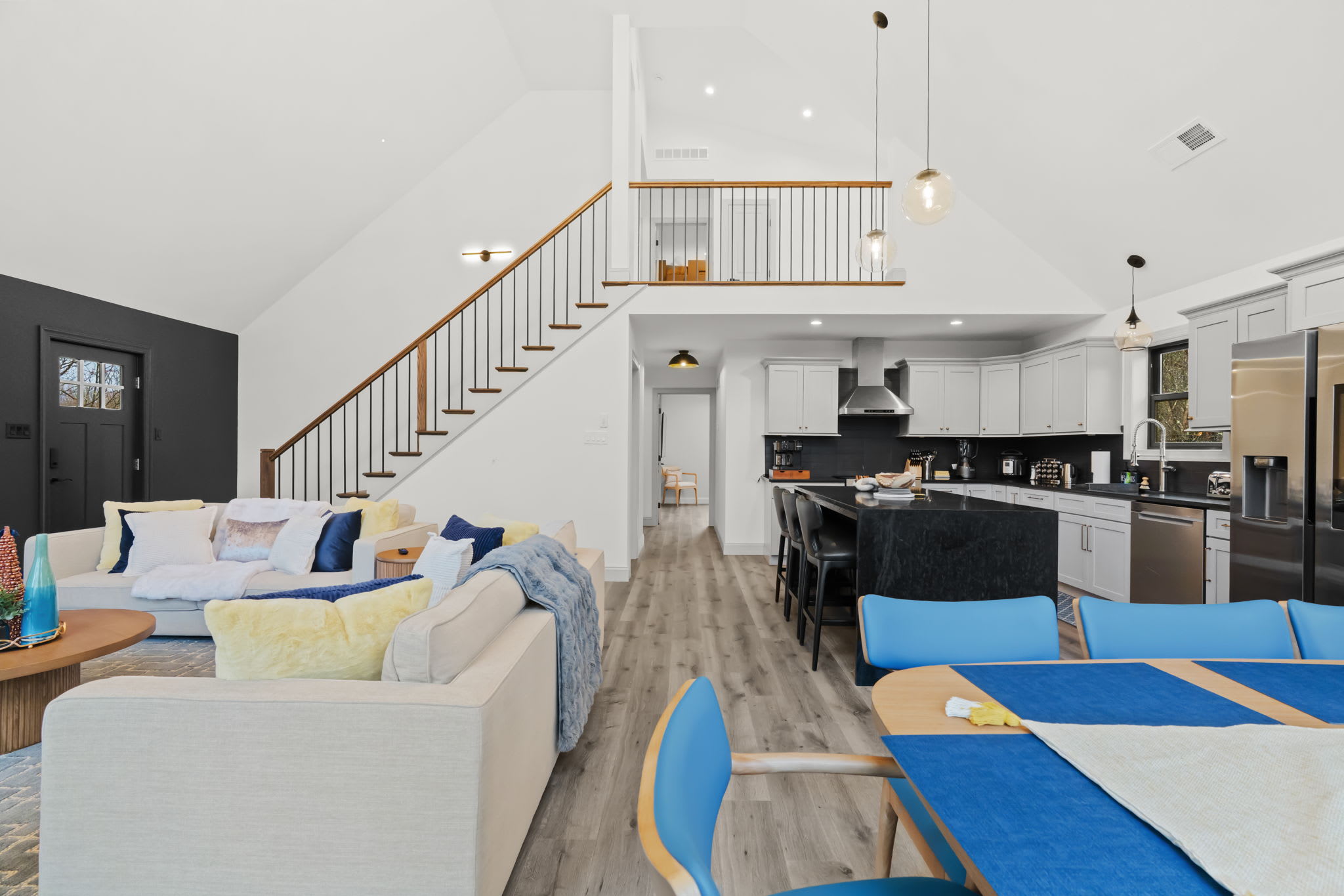 The dramatic staircase leads to the loft while the living room beckons below