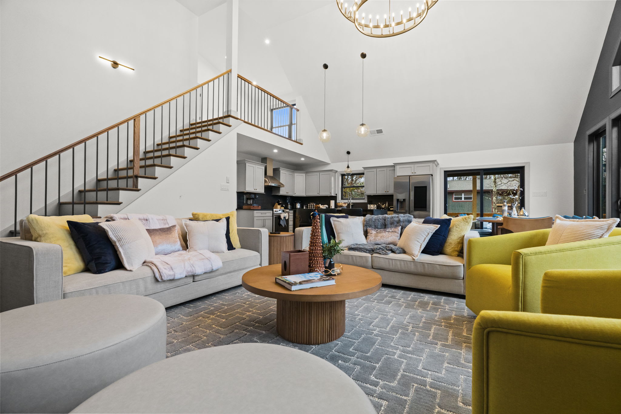 Relax on the sectional sofa near the staircase with natural light streaming through the windows