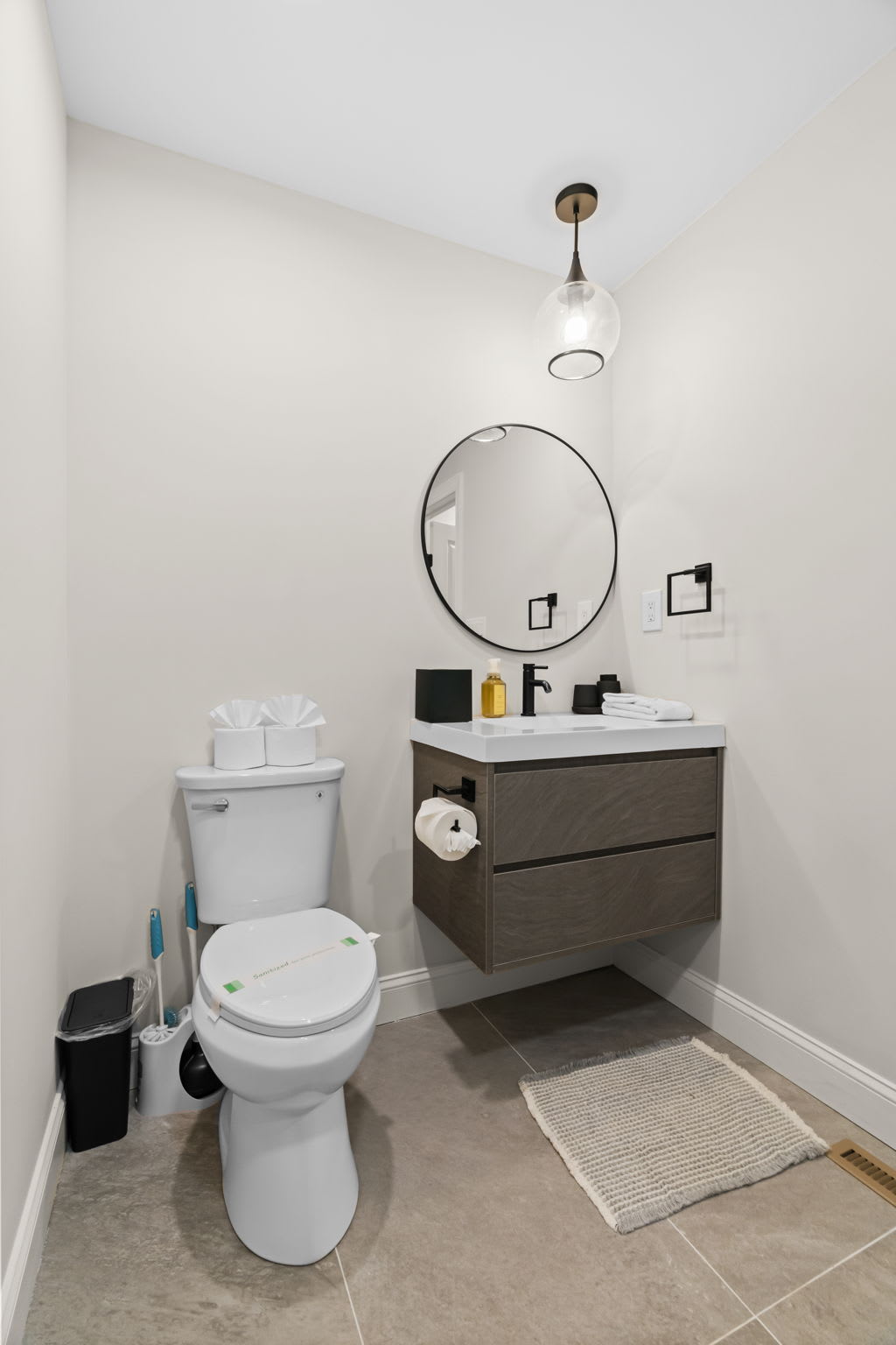 Bright and clean bathroom with modern vanity and stylish round mirror