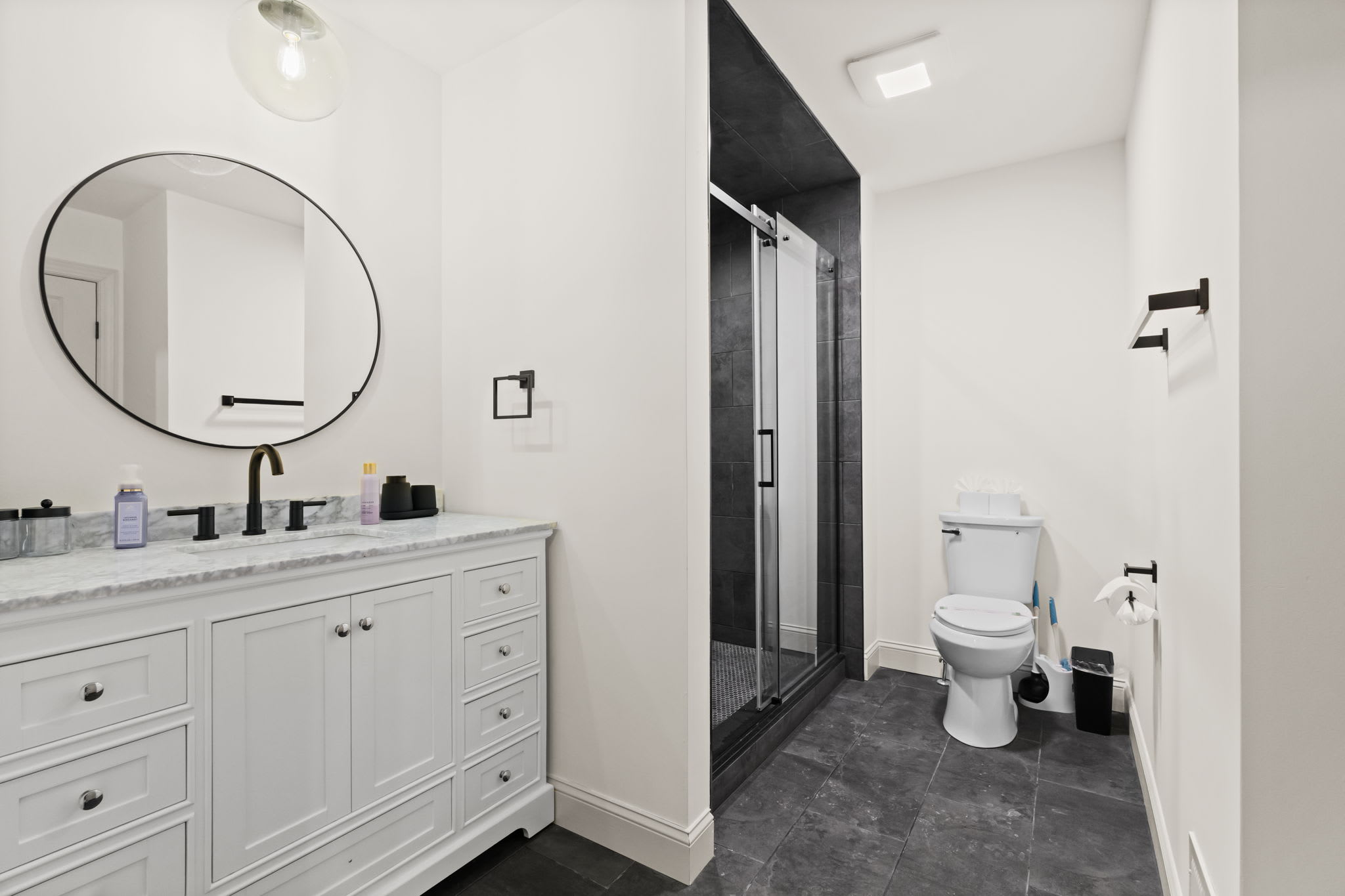 Elegant bathroom with white vanity, round mirror, and bright natural lighting