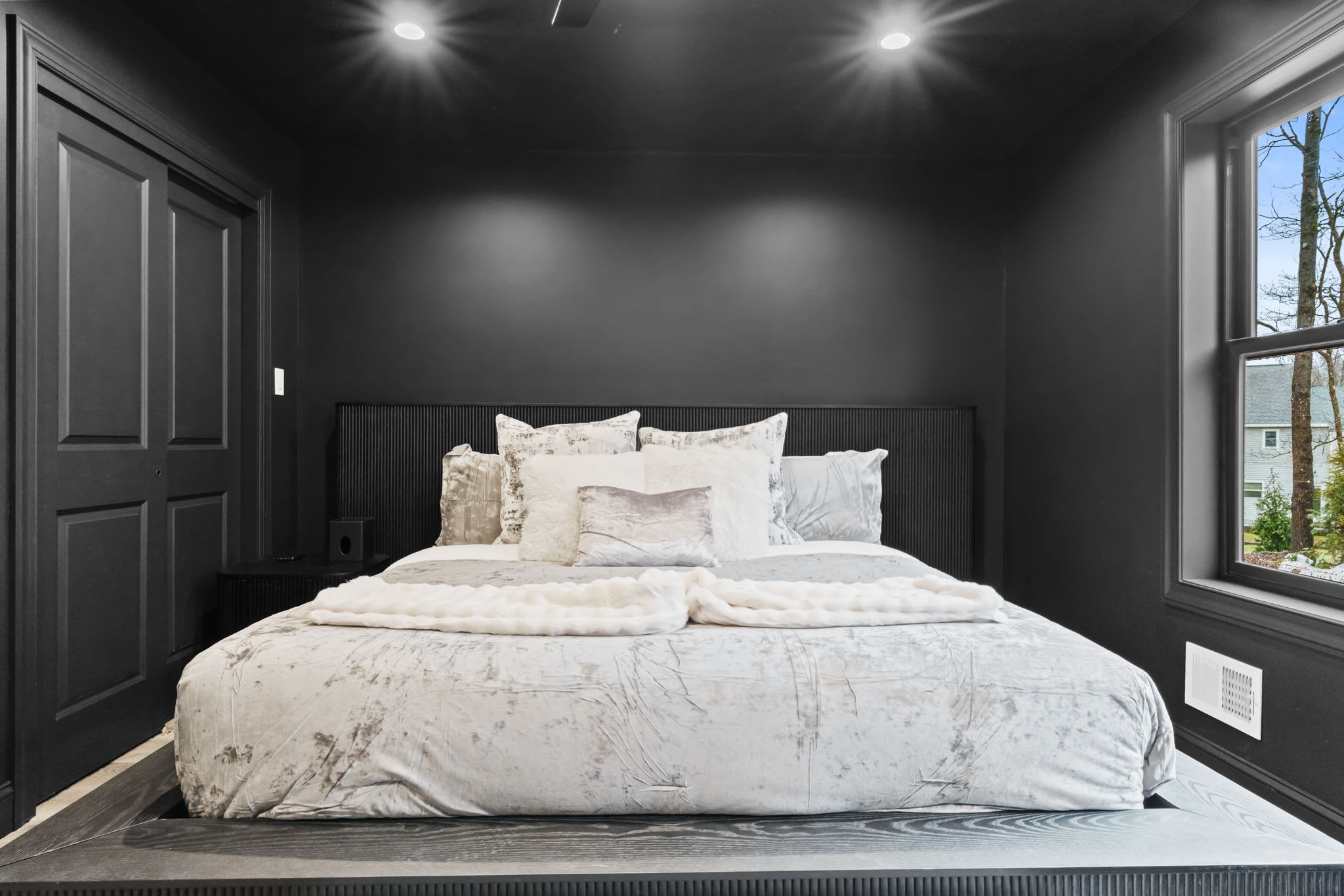 Retreat to this cozy bedroom with plush white bedding and serene forest views