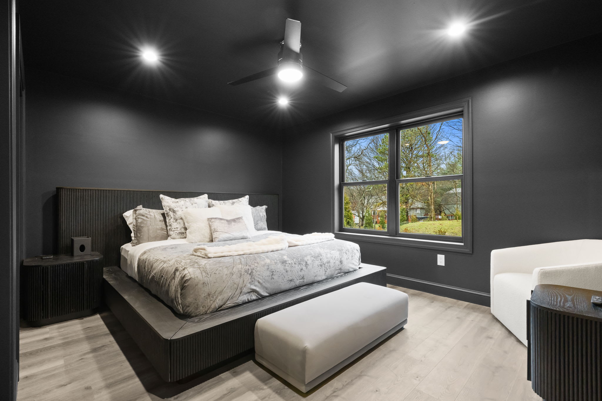 Drift off to sleep in this serene bedroom with modern decor and wooded views