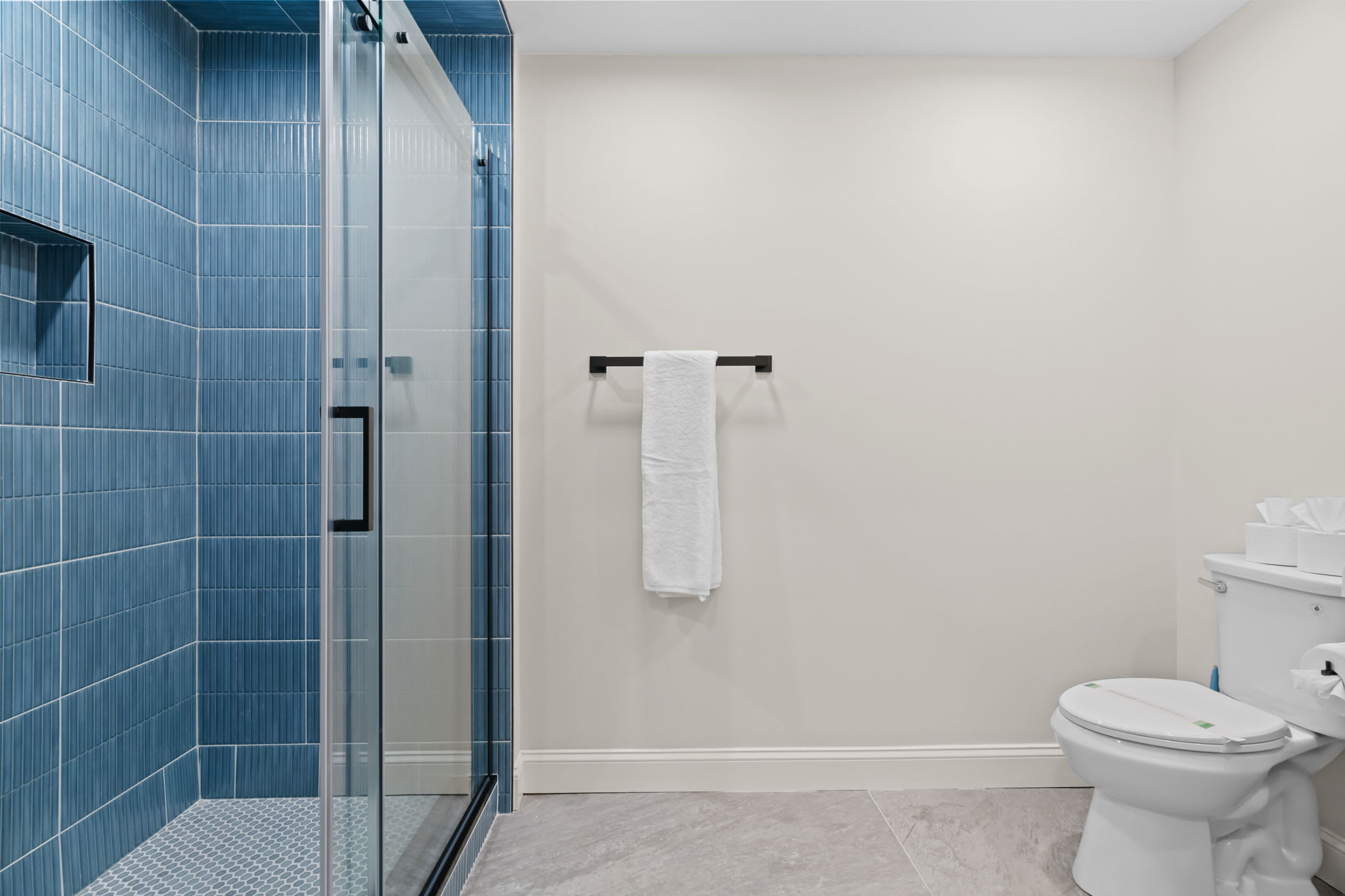 Refresh in the blue-tiled bathroom with a classic tub and shower combo