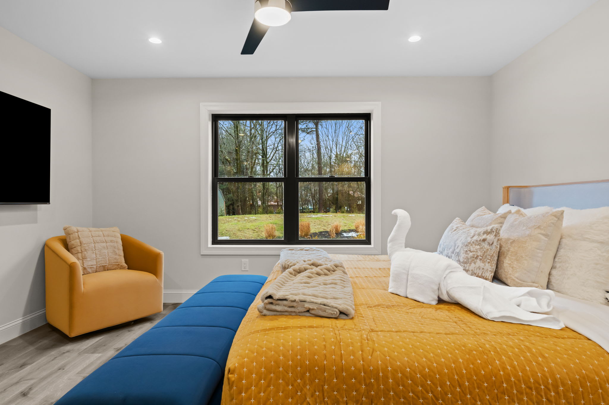 Enjoy the bright bedroom with comfortable seating and views of the treetops