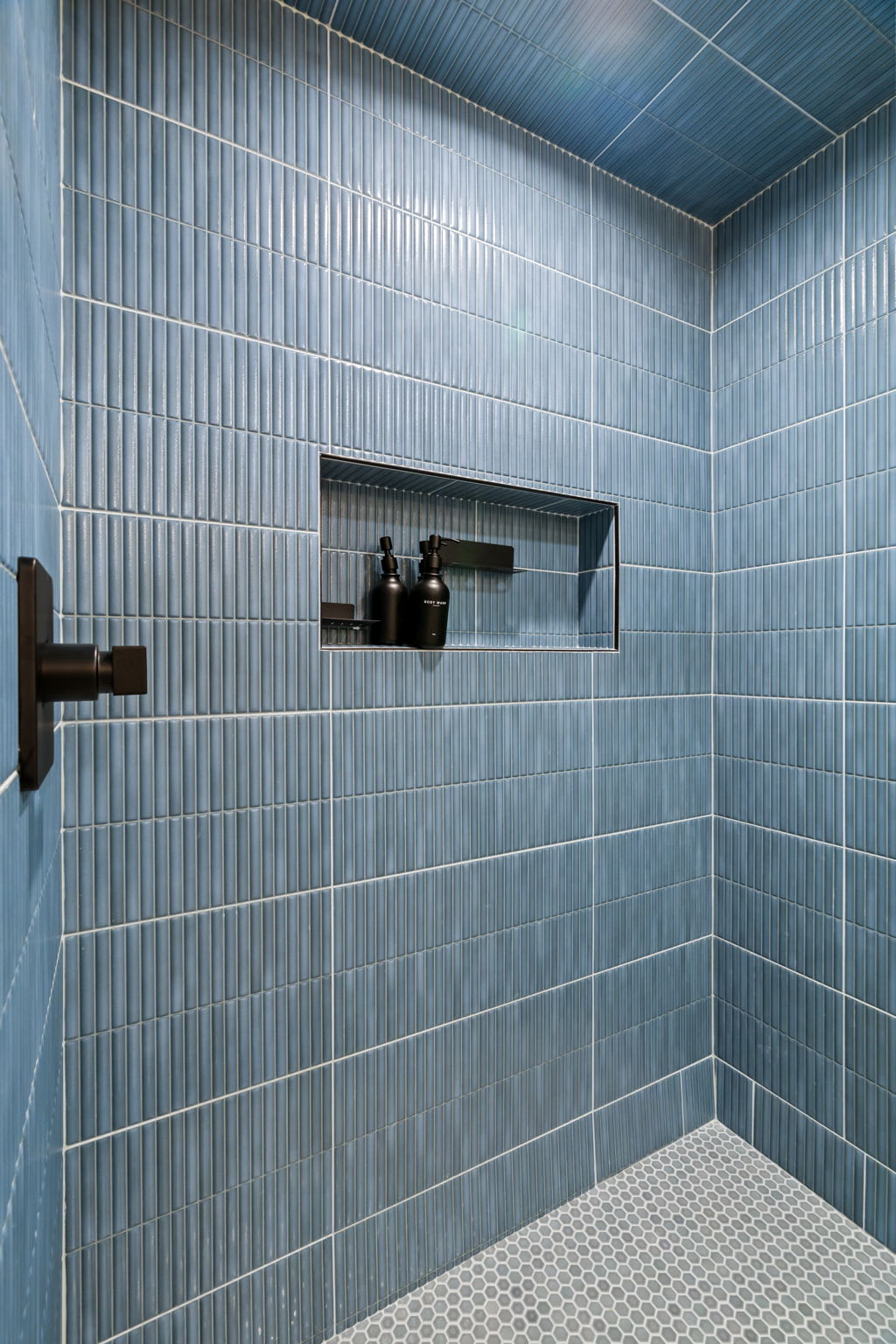 Freshen up in the charming blue-tiled bathroom with glass shower