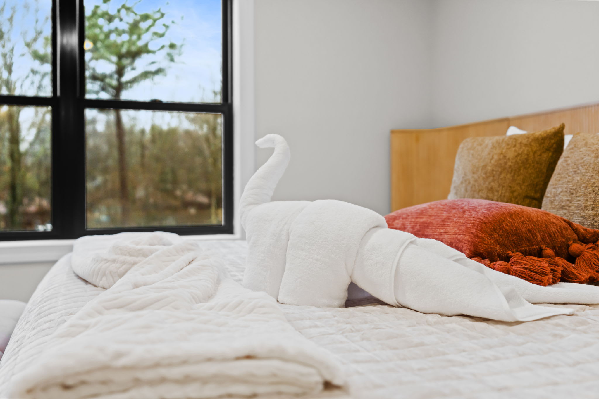 Thoughtful touches await you in the bedroom with soft linens and a window view of the trees
