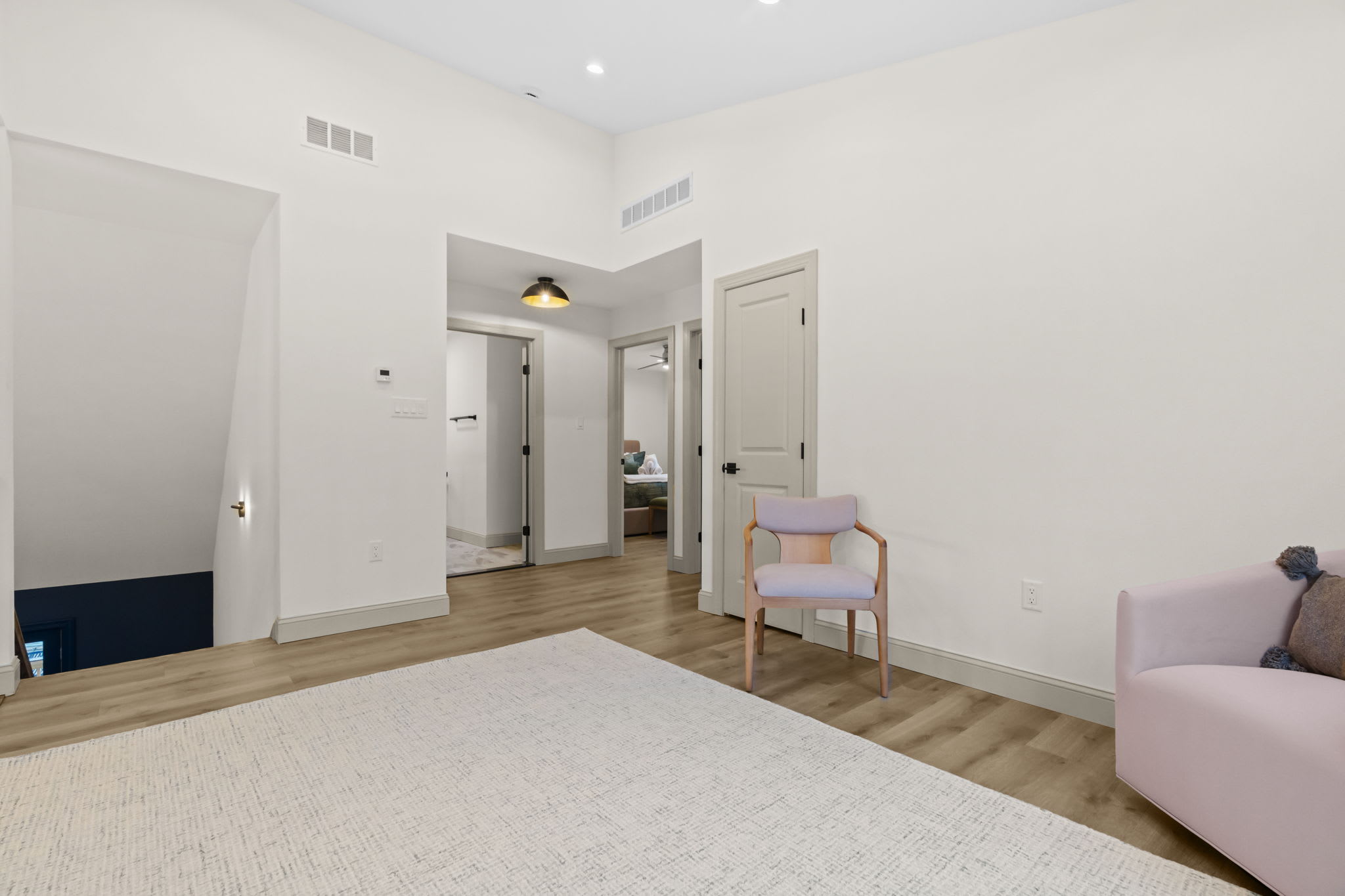 Unwind in this serene bedroom with soft pink accents and a plush bed