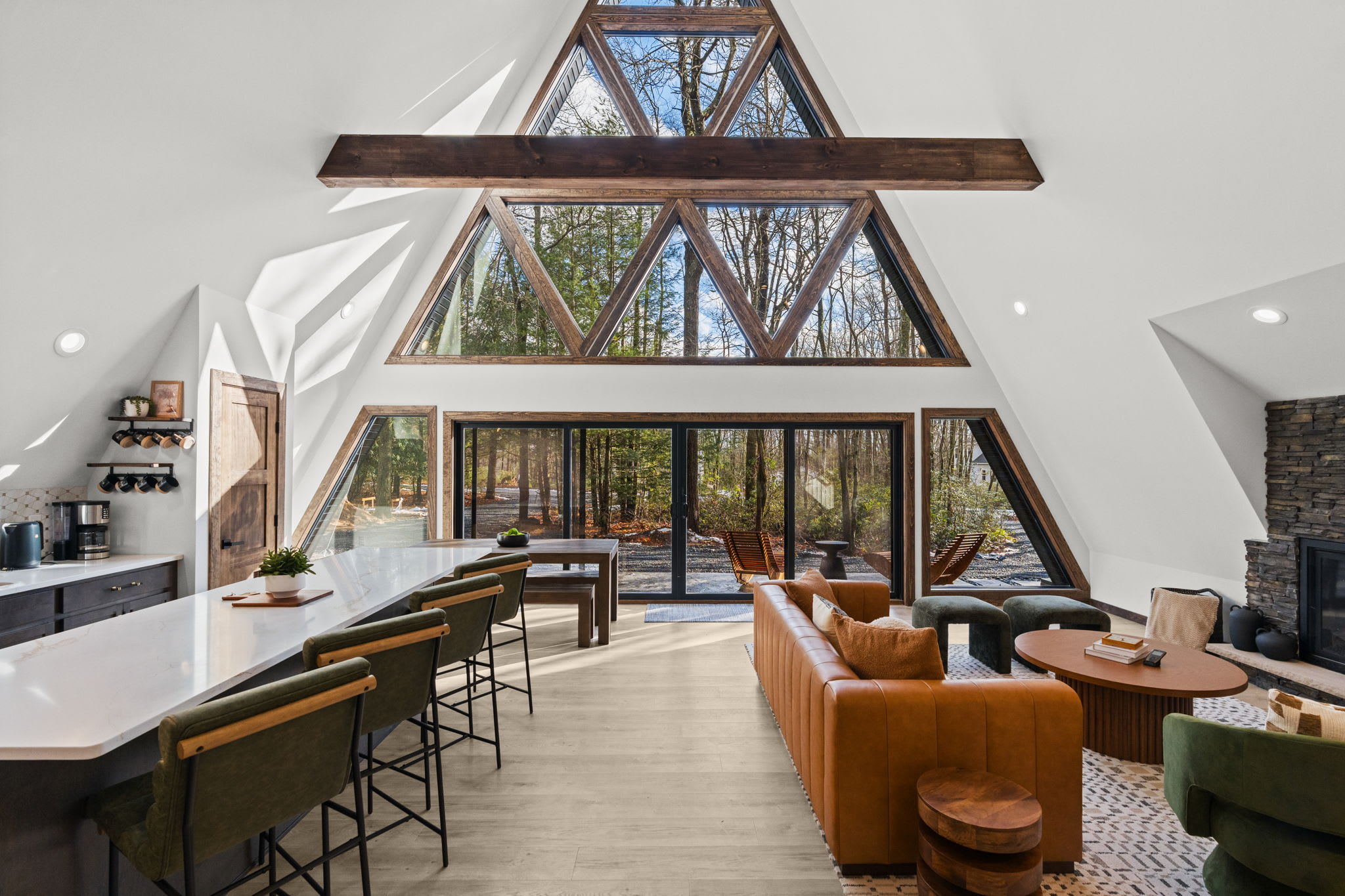 Floor-to-ceiling windows bring the forest indoors while the deck beckons outside