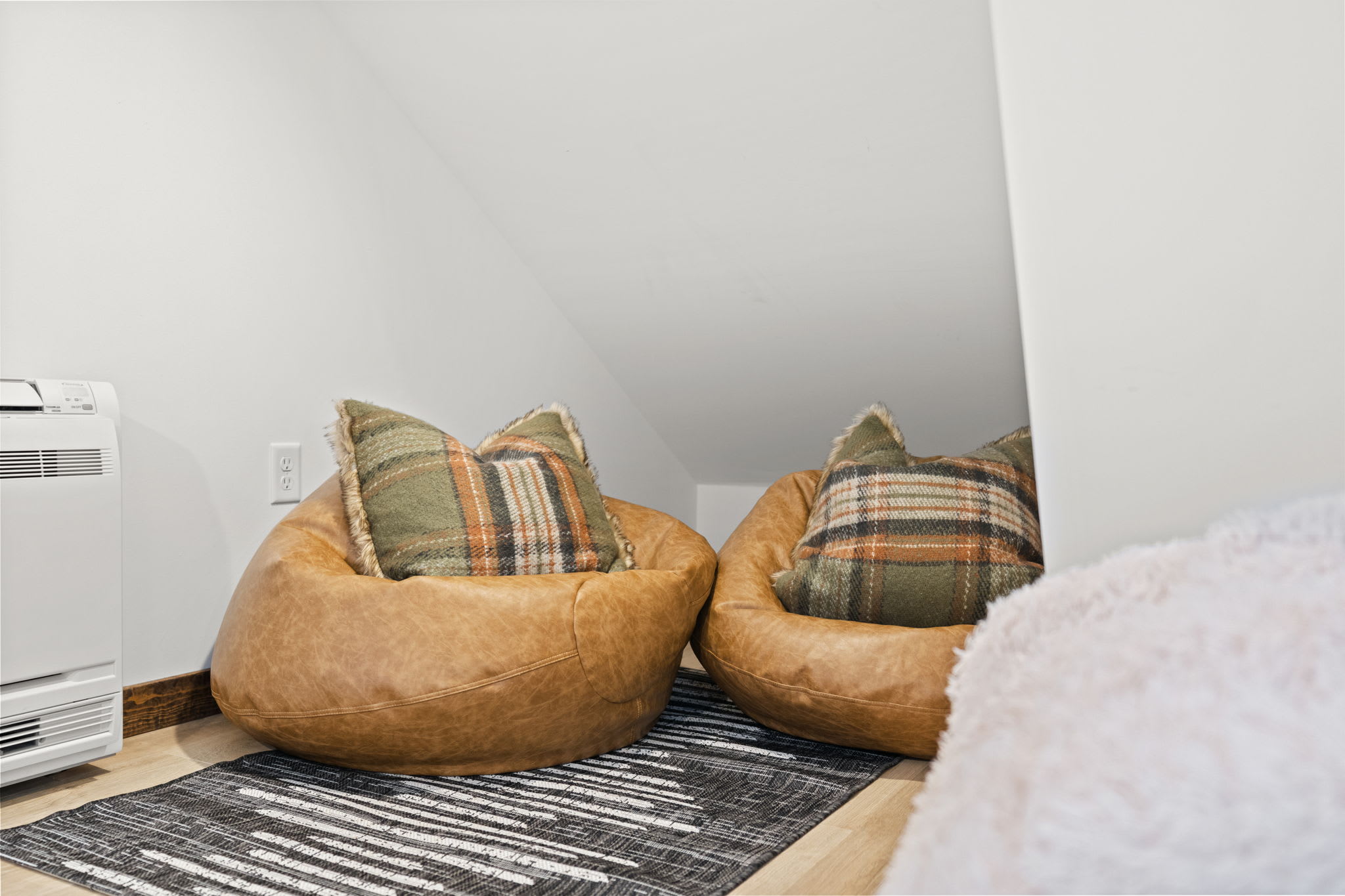 Comfy floor poufs invite you to curl up in the loft sleeping nook