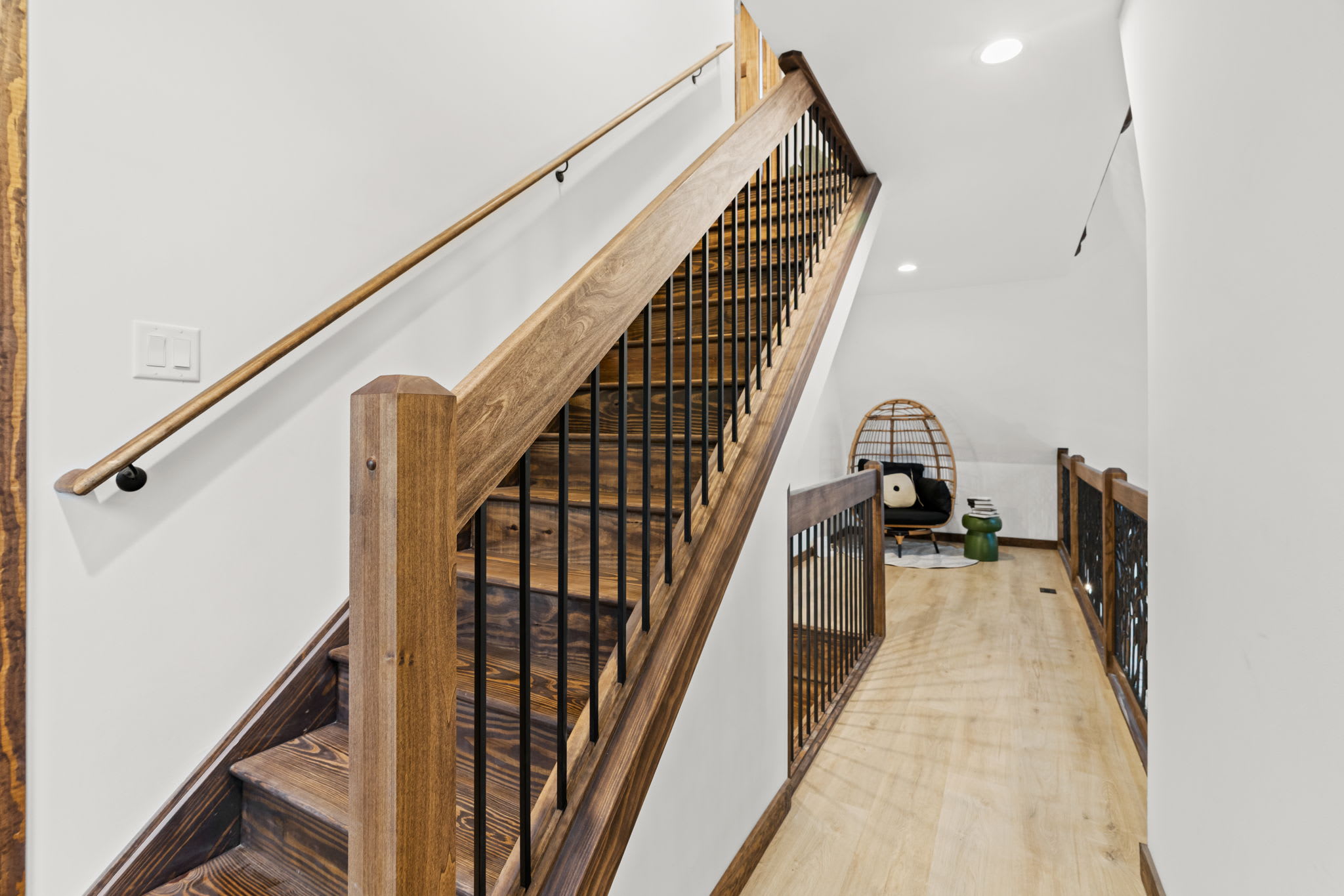 Upper hallway leads to the loft ladder with forest views through the A-frame window