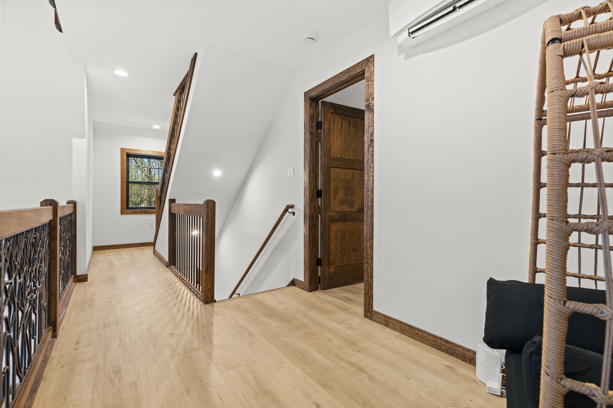 Upper hallway leads to the cozy loft bedroom with A-frame window views