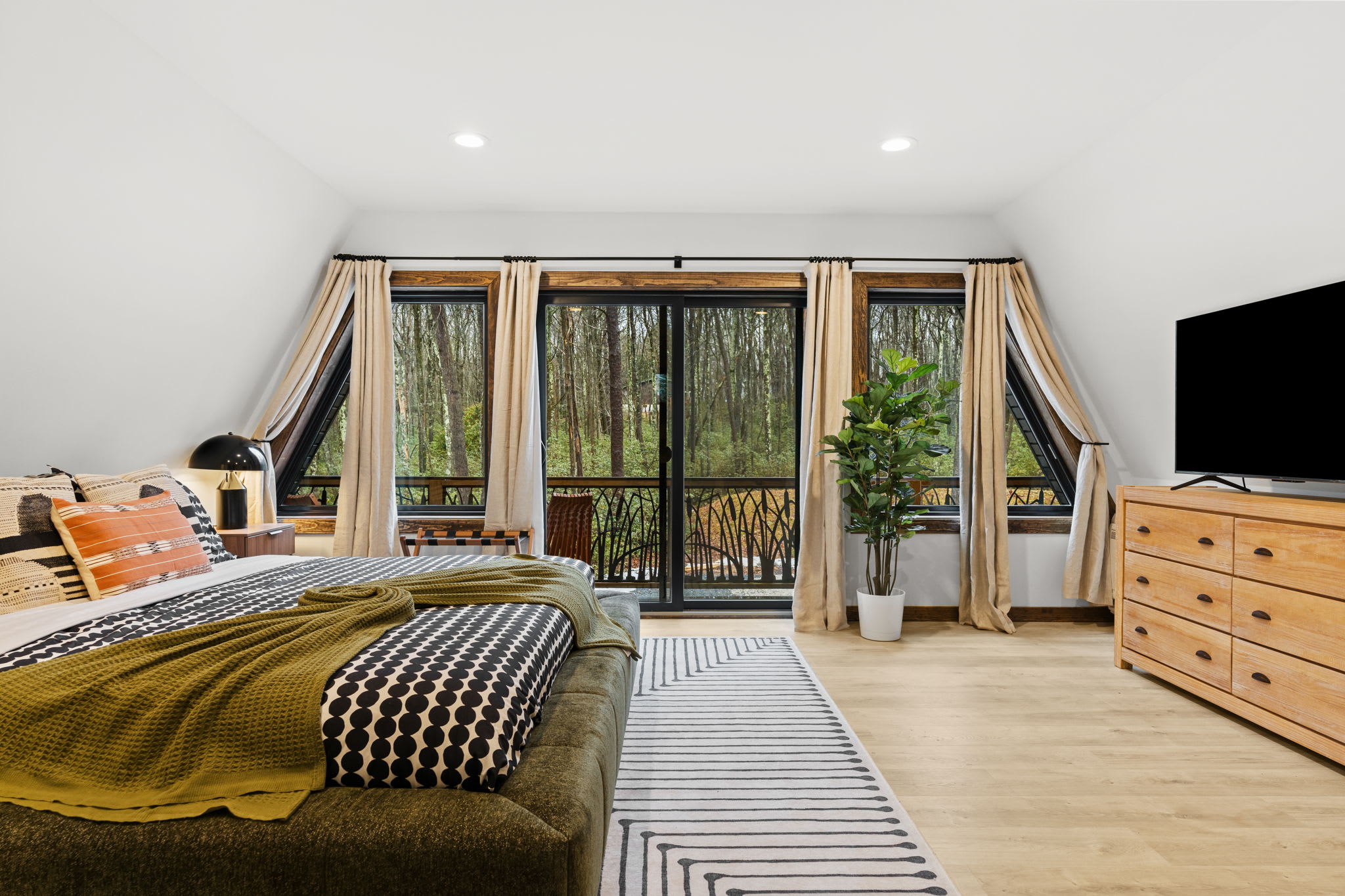 Wake up to treetop views with the TV and balcony access in the third bedroom
