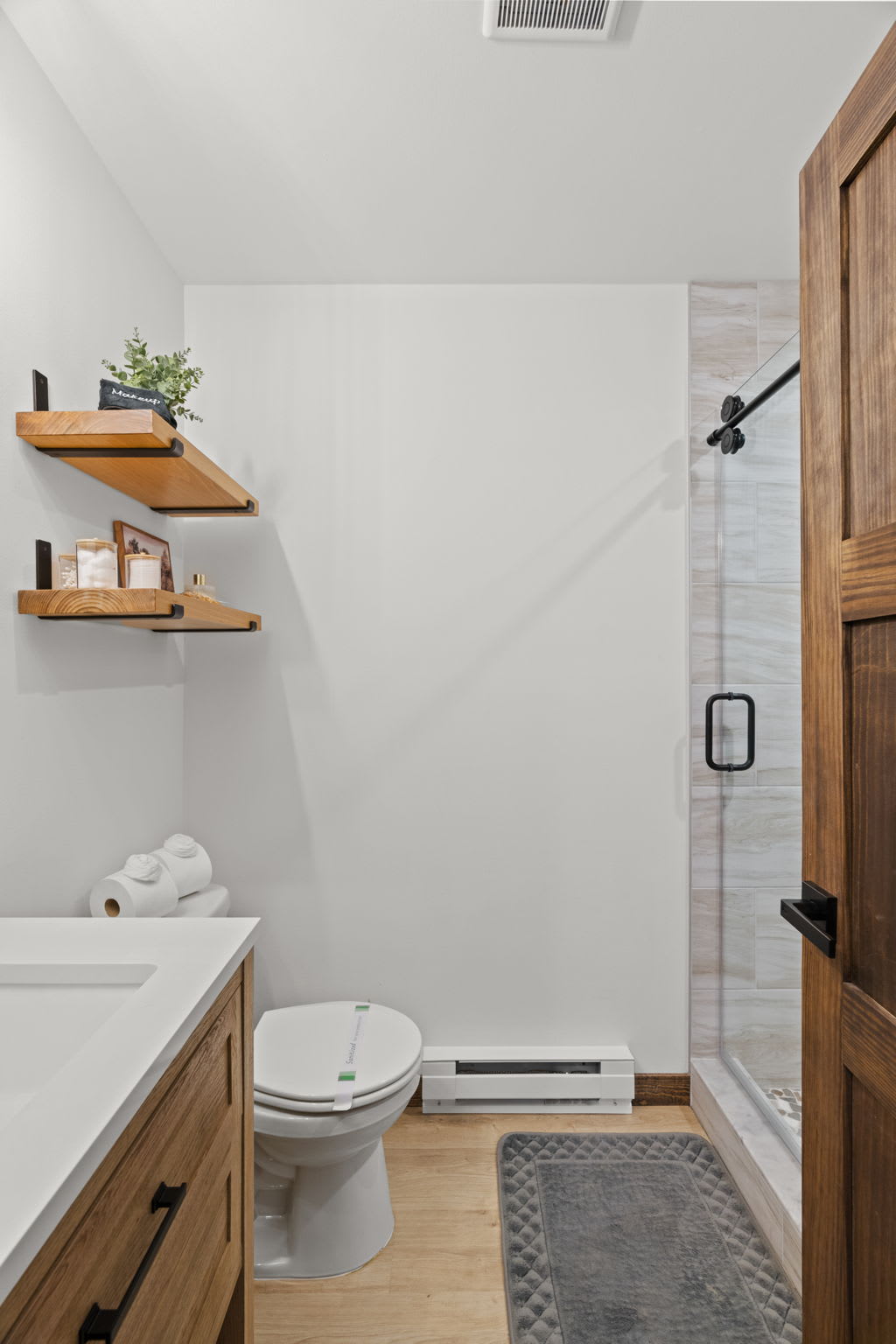 Step into the spacious walk-in shower with rainfall showerhead and stone tile