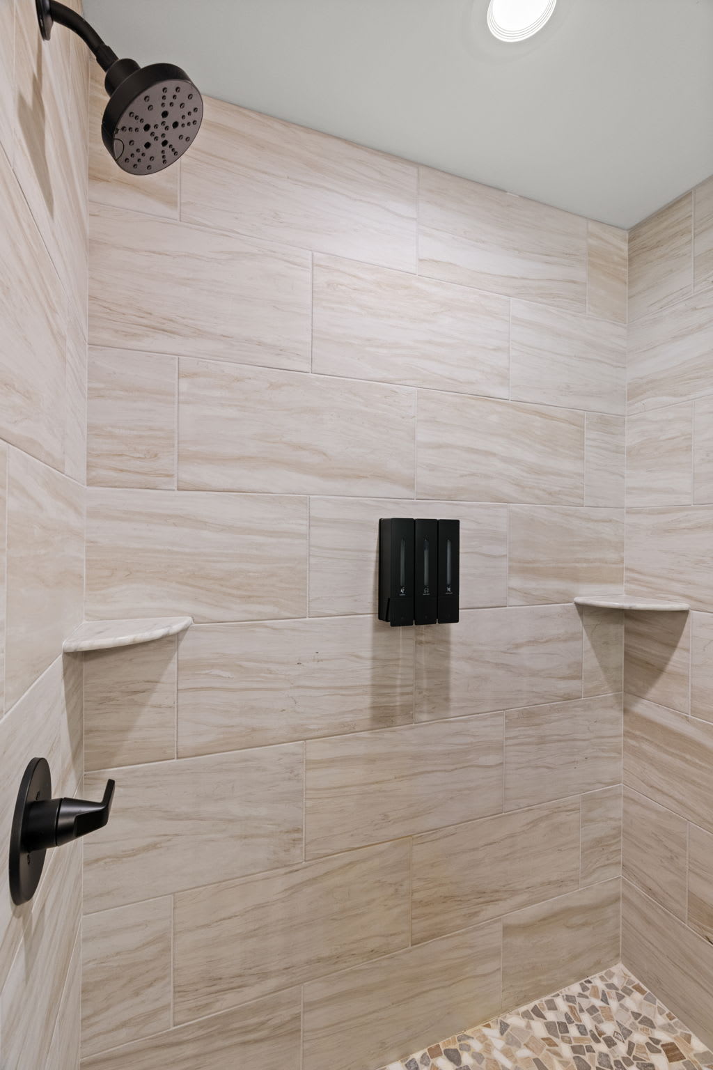 Second bathroom features a spa-style shower with stone tile and black fixtures