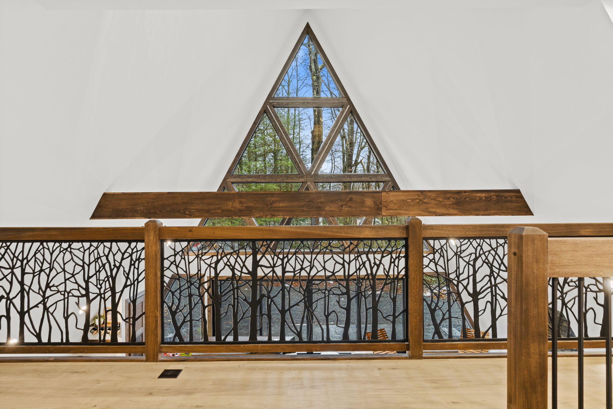 Gaze up through the towering A-frame windows framed by artisan tree branch railing