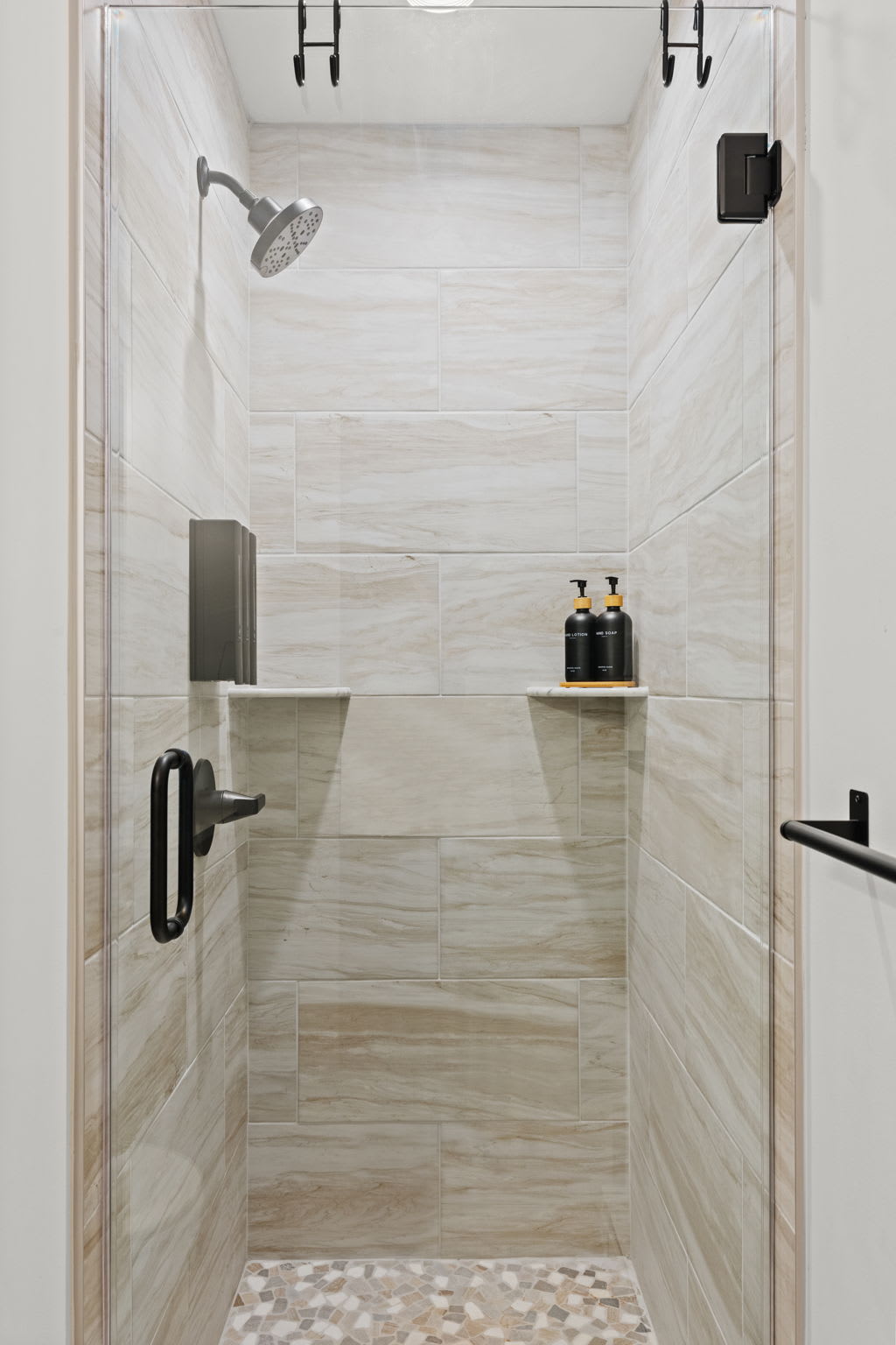Refresh in the walk-in shower with built-in shelving and black fixtures