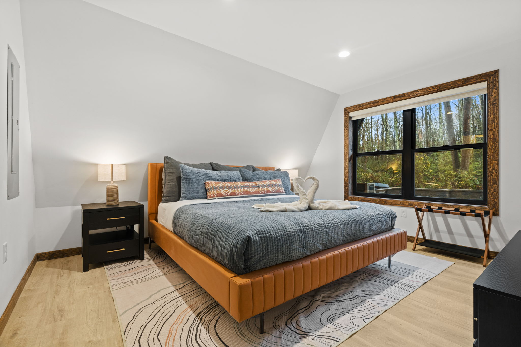 Settle into the second bedroom with king bed and forest views through large windows