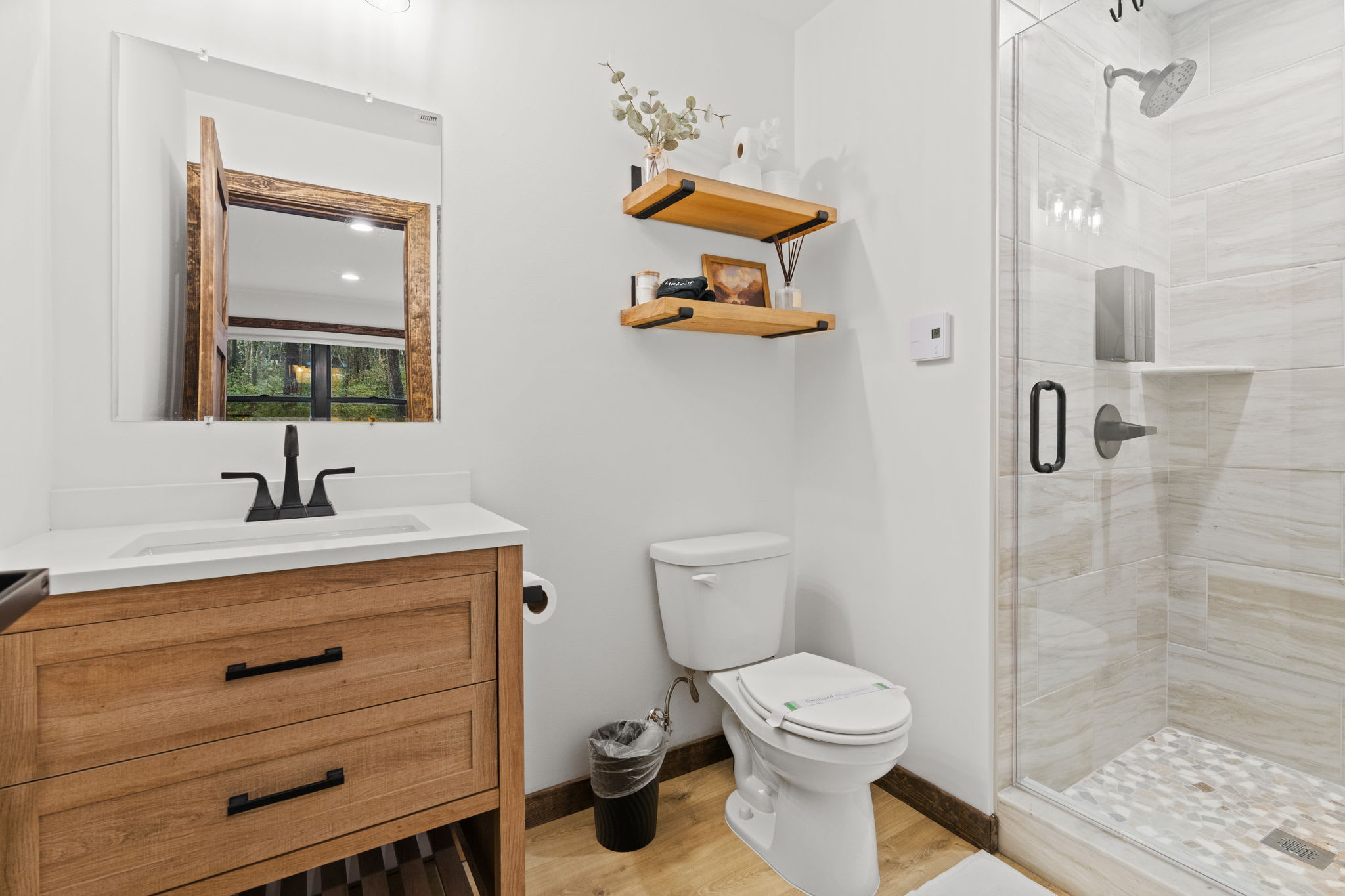 Spa-like second bathroom with wooden vanity and walk-in tile shower