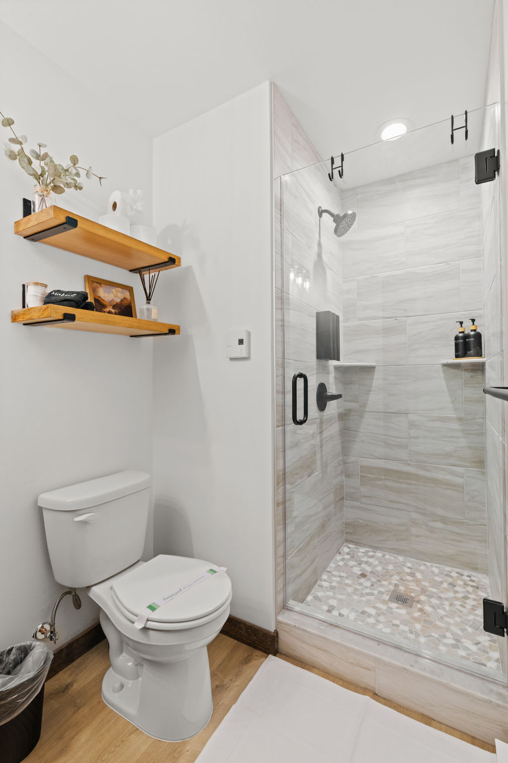 Walk-in shower with stone tile and rainfall showerhead in the second bathroom