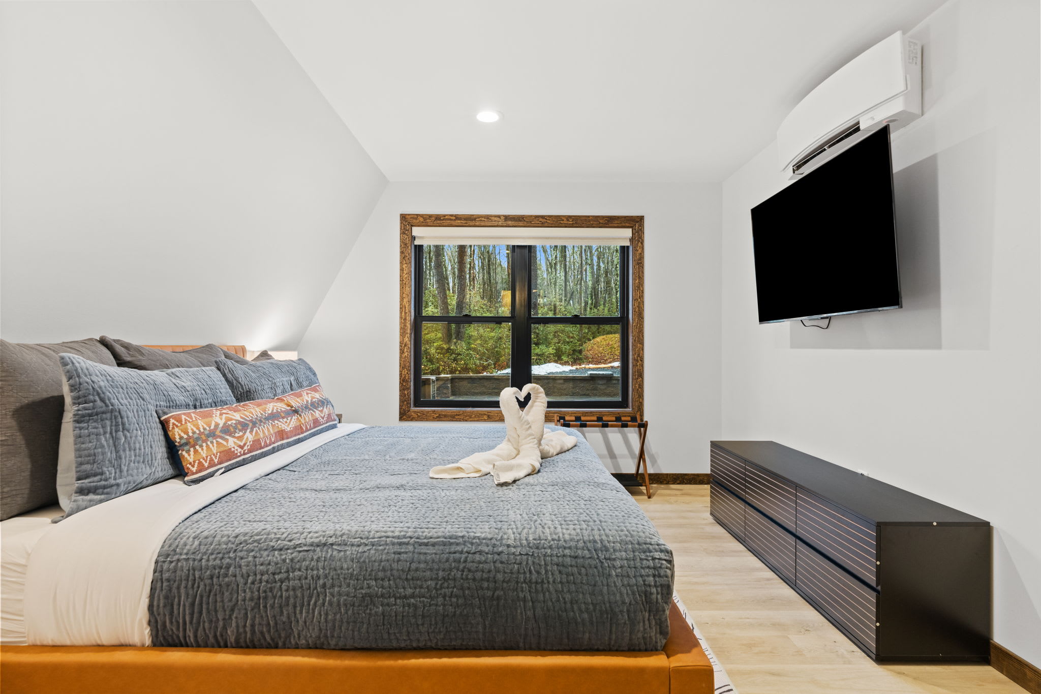 Unwind in the second bedroom with your own TV and treetop views