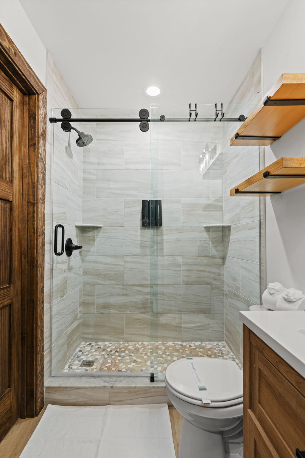 Elegant tile work and pebble flooring in the primary bathroom shower