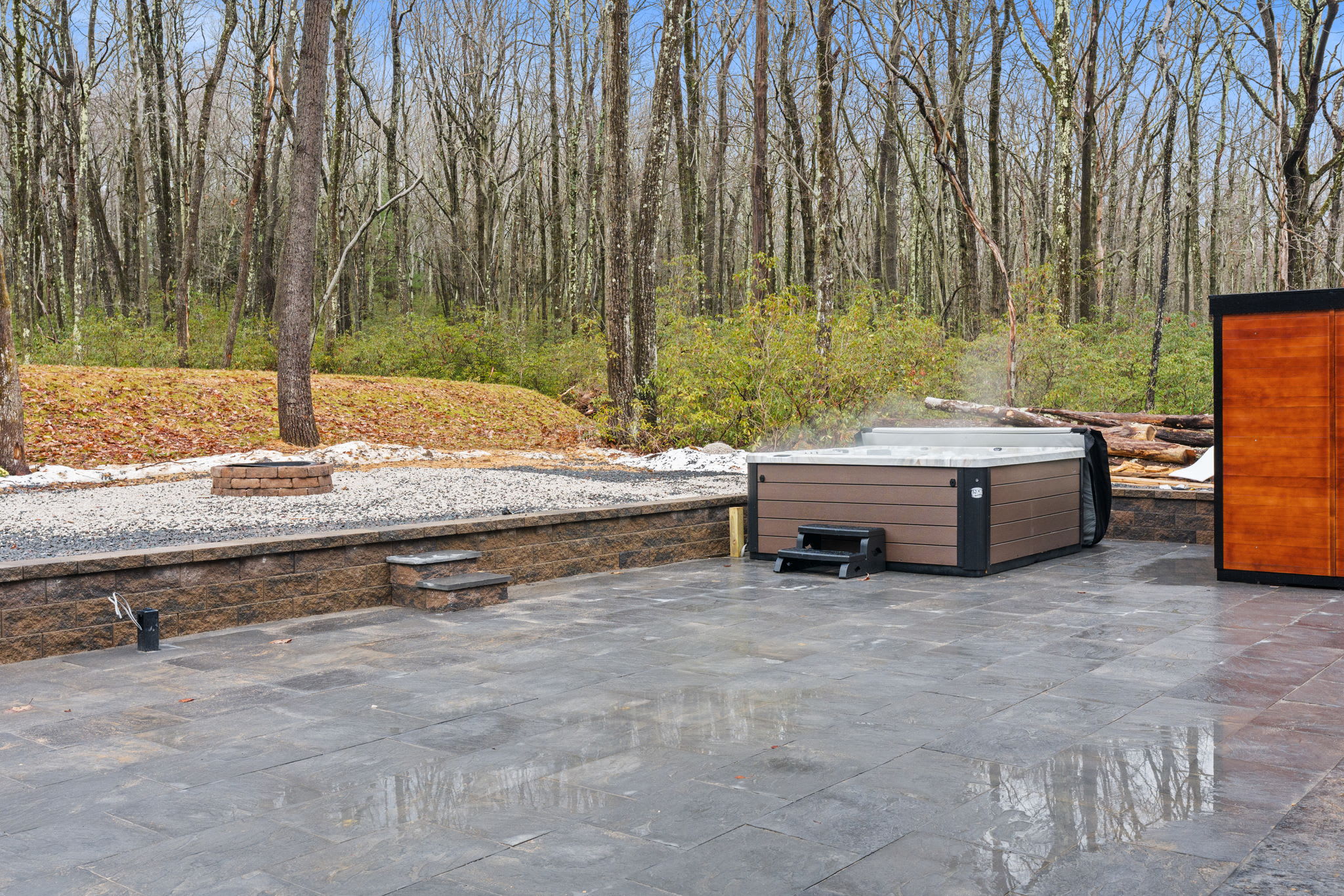 Step into your backyard retreat with hot tub and sauna on the stone patio