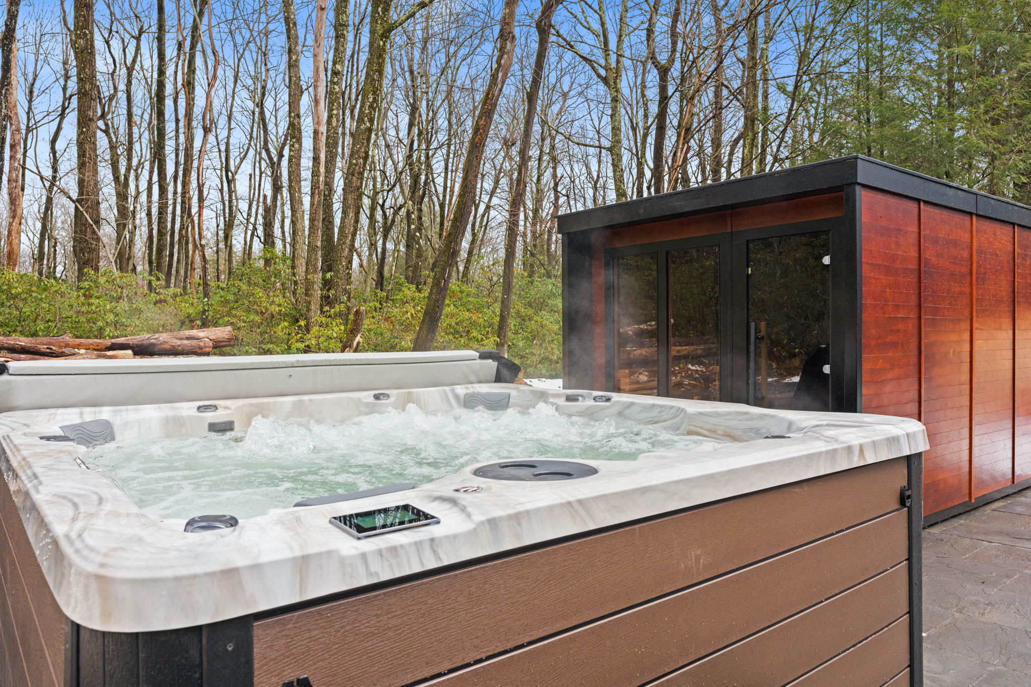 Unwind in the bubbling hot tub with the sauna steps away, nestled in the forest