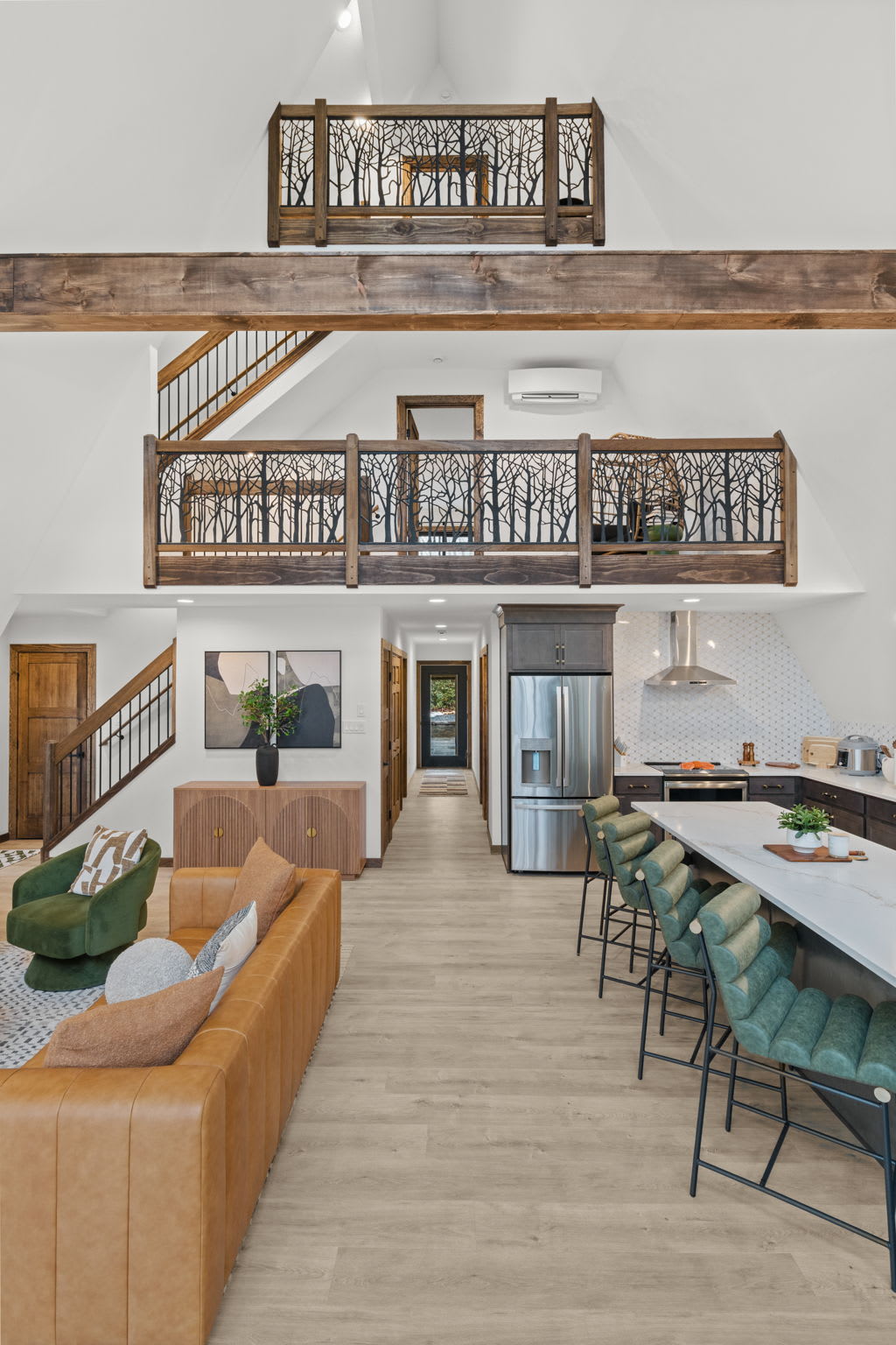 Teal bar stools line the kitchen island in this open concept living space.