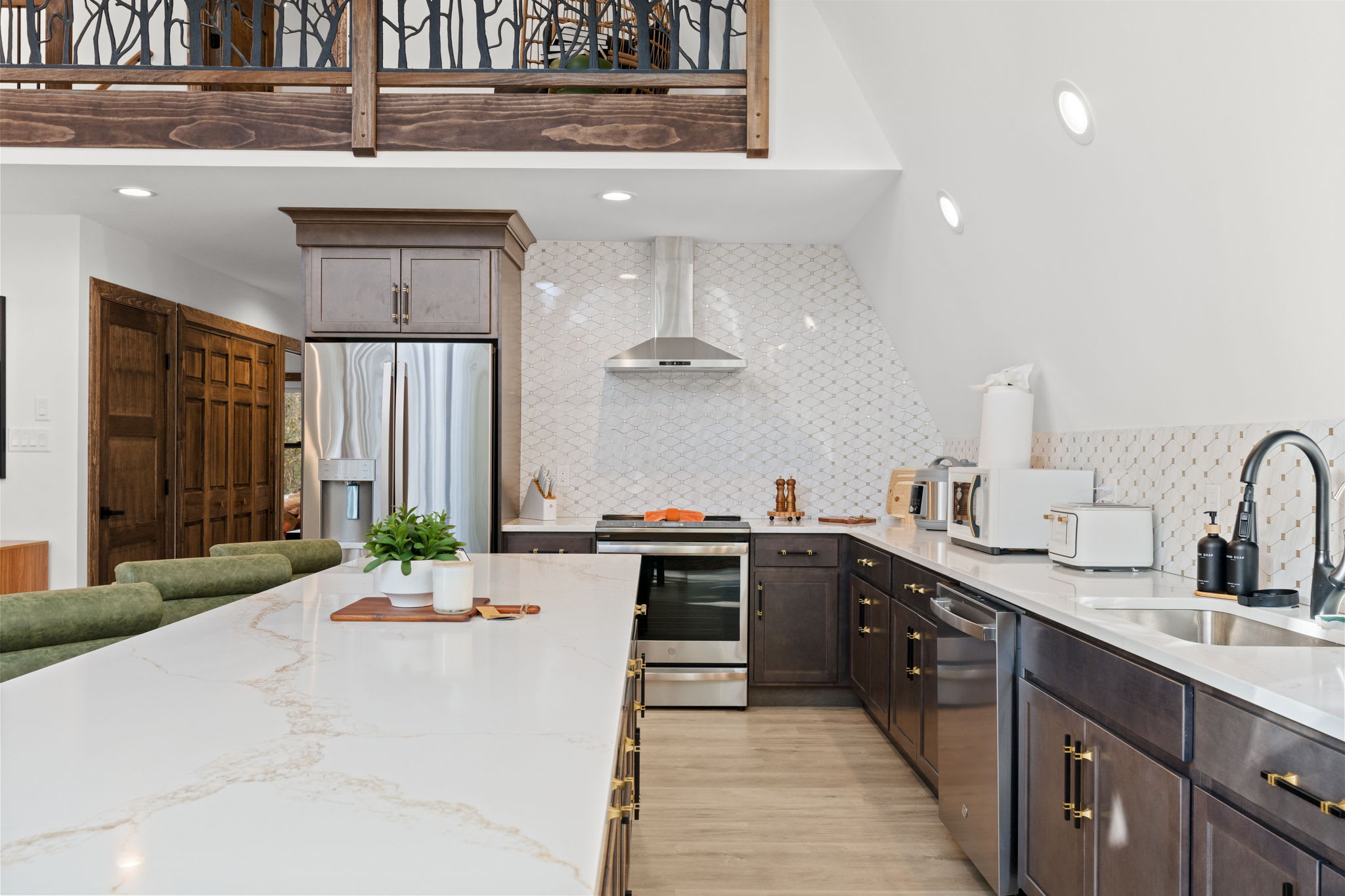 Fully equipped kitchen with dark cabinetry, wood counters, and modern fixtures.
